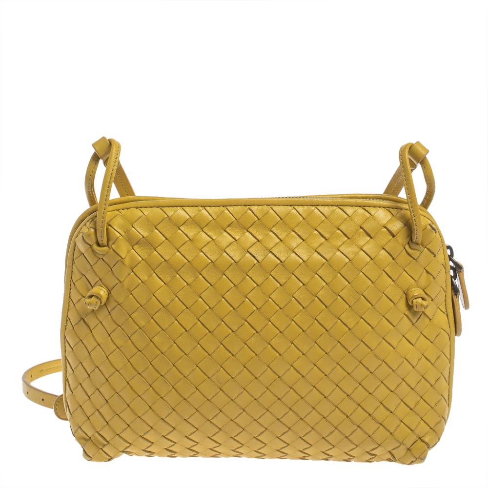 This Nodini bag from Bottega Veneta is crafted from yellow leather using their signature Intrecciato weaving technique flaunting a seamless silhouette. Brimming with artistry and quality craftsmanship, the bag has an interior that is spacious enough
