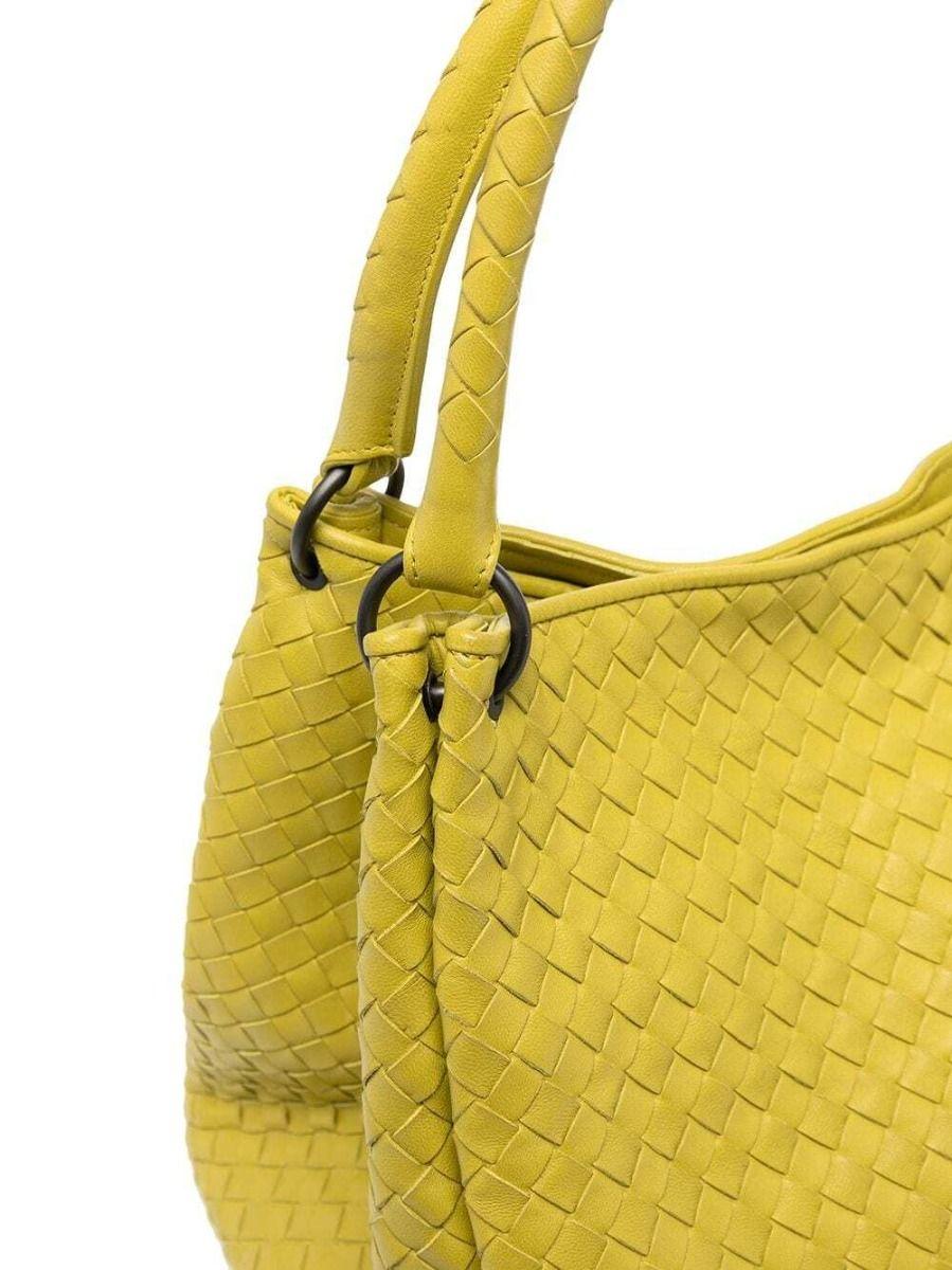 Crafted in Italy from fine leather in yellow, this pre-owned Bottega Veneta bag incorporates the label's iconic intrecciato weave, a concealed magnetic fastening and two rounded top leather handles. The bag opens up to a large interior that provides
