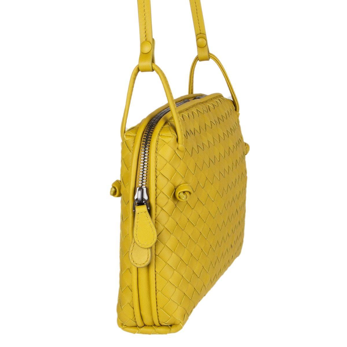 Bottega Veneta 'Nodini' cross-body in chartreuse woven nappa leather. Opens with a two-way zipper on top. Lined in dark taupe suede with one open pocket against the front and a zipper pocket against the back. Has an adjustable shoulder strap. Comes