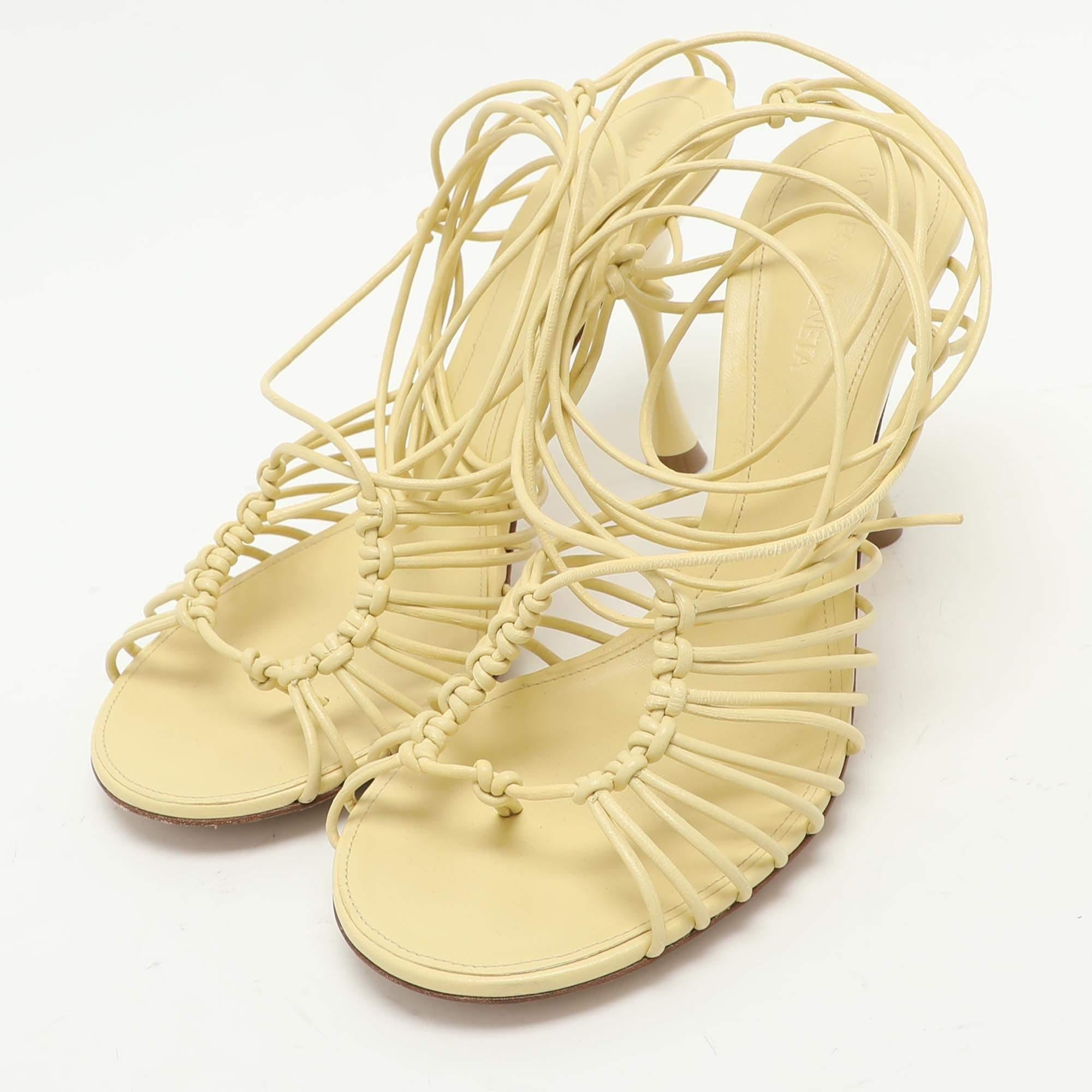 Ci piace il modo in cui il giallo fa risaltare il meglio del design delle scarpe. Questi sandali in pelle di Bottega Veneta sono caratterizzati da una struttura a strappo e da punte aperte.  Allacciatura alla caviglia  e tacchi di 9 cm.