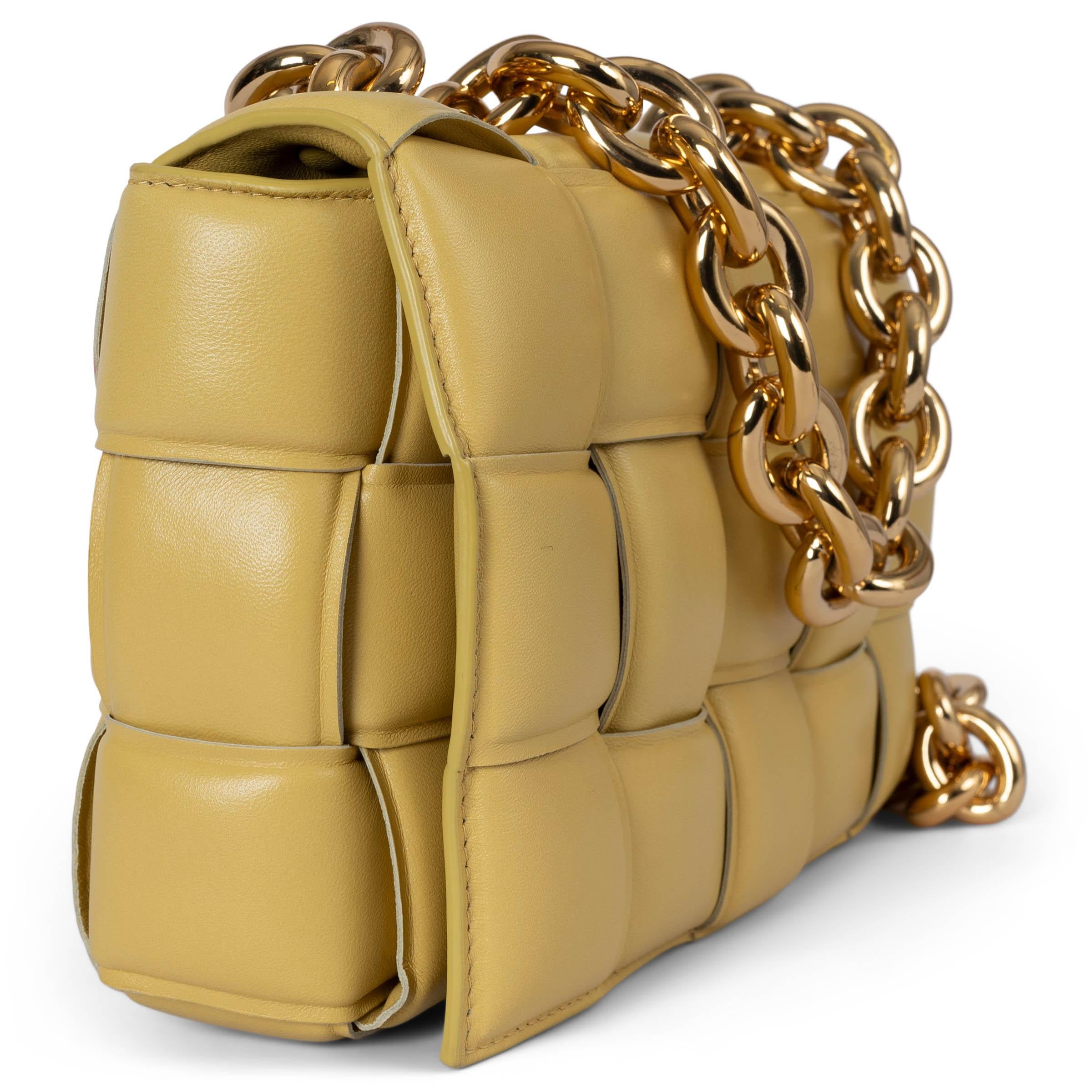 This 100% authentic Bottega Veneta Chain Cassette flap shoulder bag in Corn yellow is crafted from padded Maxi Intrecciato Nappa leather, offering a bold yet sophisticated design. It features a chunky gold-tone chain top handle and strap, adding a