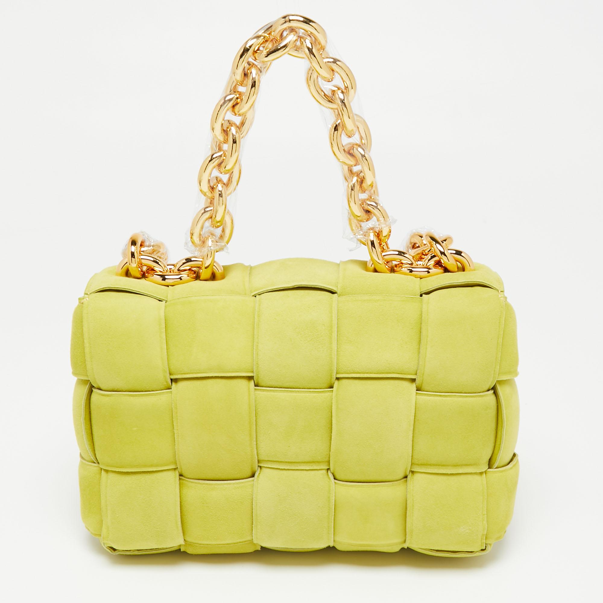 This lovely bag on many fashionistas' minds is the Cassette bag from the house of Bottega Veneta. We have here the one in yellow suede, flaunting a padded weave and chunky chain handles. The insides are sized to fit your phone, wallet, and make-up