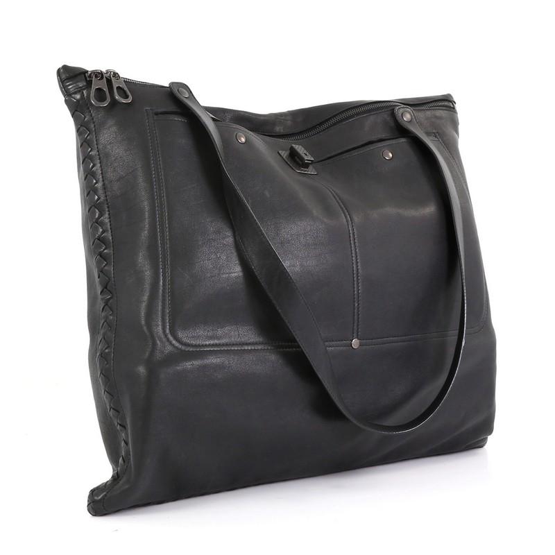 This Bottega Veneta Zip Front Pocket Shopping Tote Leather with Intrecciato Detail Large, crafted in black leather features dual flat handles, intrecciato detailing, exterior front pockets and gunmetal-tone hardware. Its zip closure opens to a black