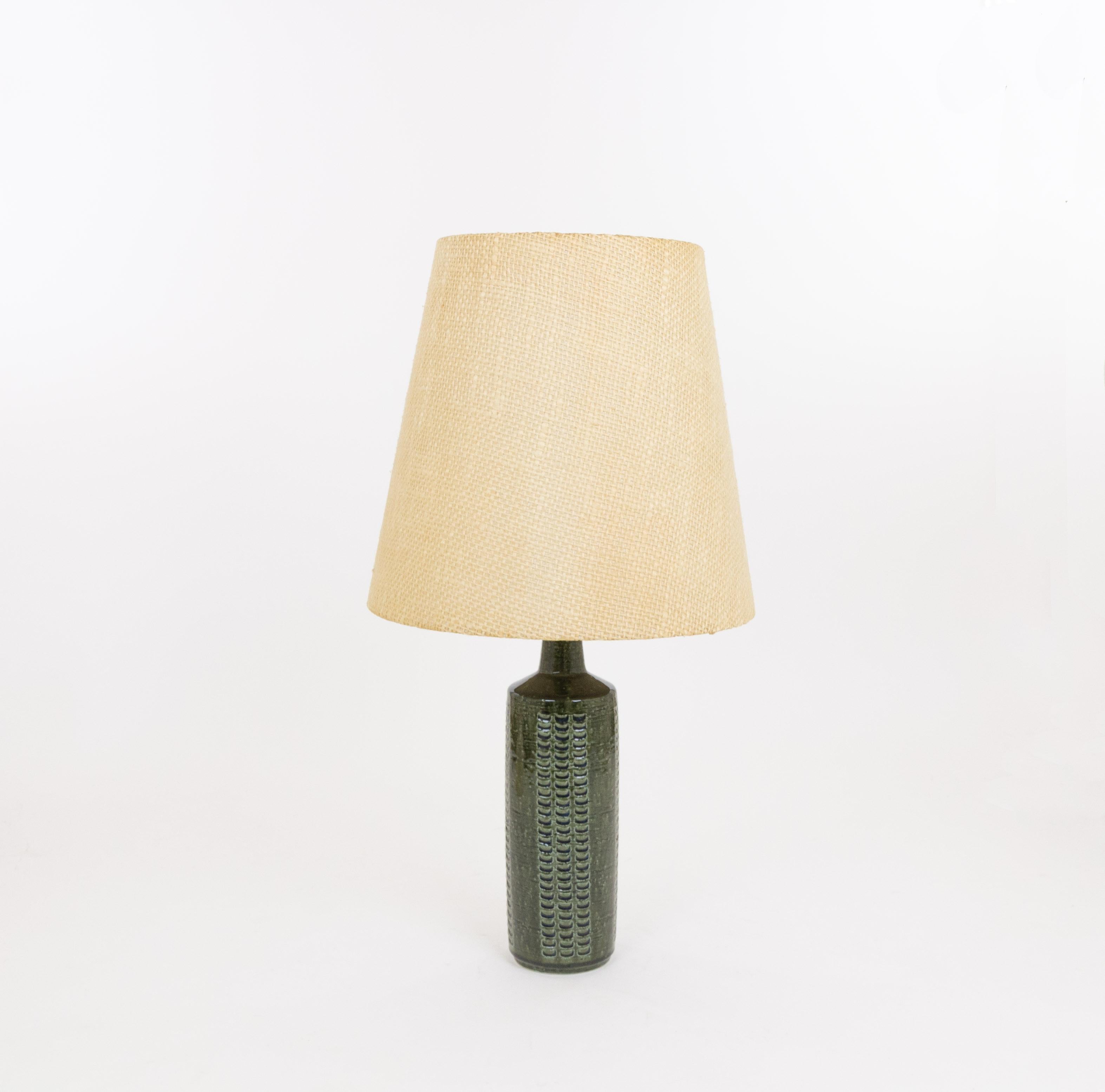 Model DL/27 table lamp made by Annelise and Per Linnemann-Schmidt for Palshus in the 1960s. The colour of the handmade decorated base is Bottle Green, with traces of midnight blue. It has impressed patterns.

The lamp comes with its original