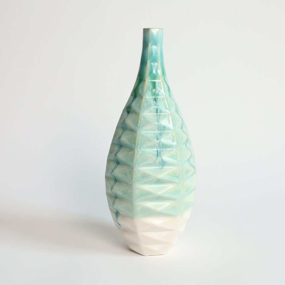 Bottle Patterned Vessel in Jade
Introducing the Bottle Patterned Vessel, a beautiful and contemporary piece of art that seamlessly blends traditional craftsmanship with modern design. This stunning vase features an intricate pattern that adorns its