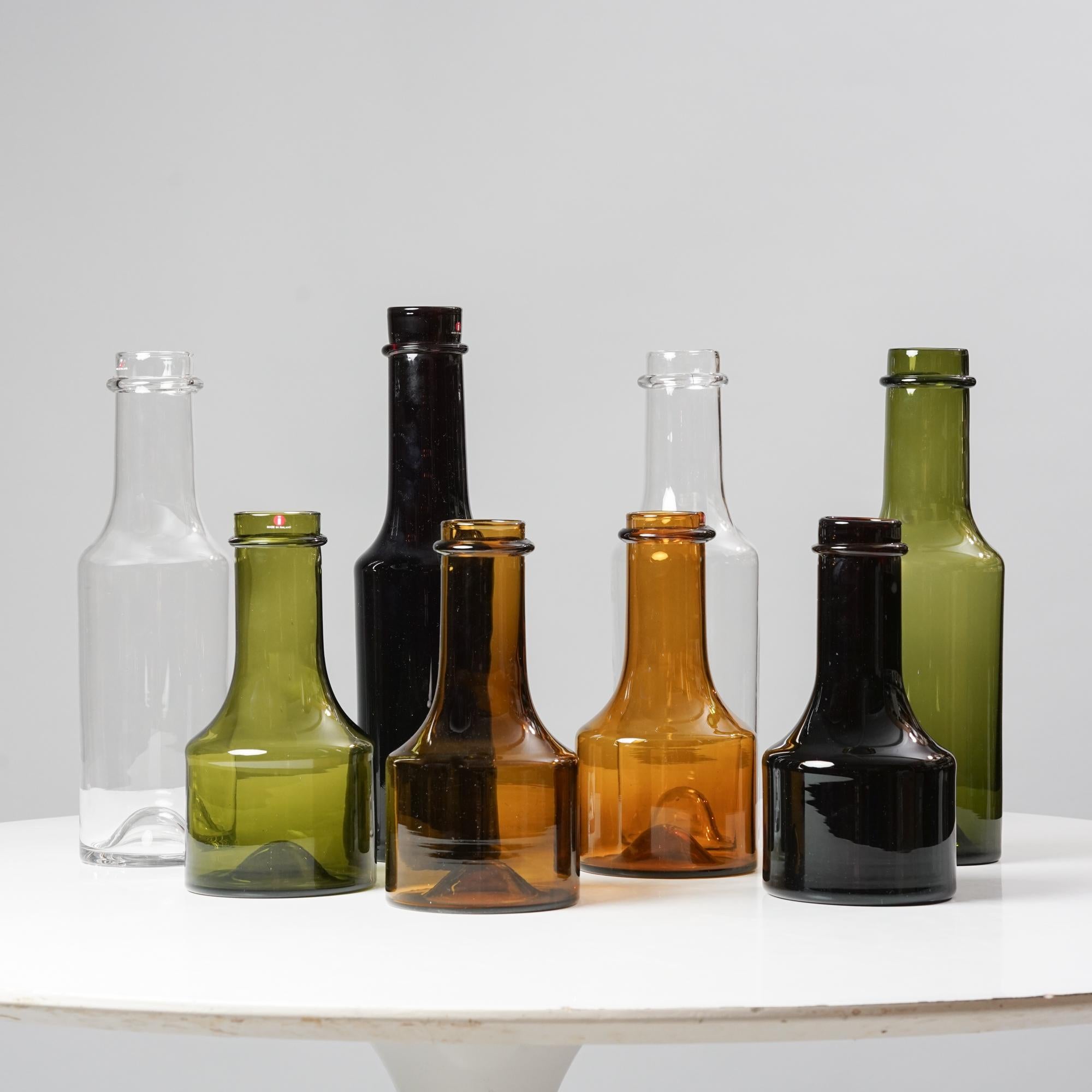 Bottle Set models 2507 & 2508 designed by Tapio Wirkkala, manufactured by Iittala, Mid-20th Century. The set includes 8 bottles. Marked and signed. Good vintage condition, minor patina and wear consistent with age and use. The bottles are sold as a
