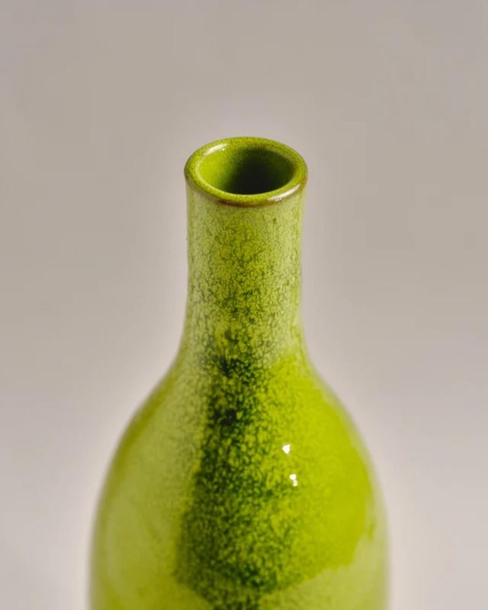 Vase aus glasierter Keramik in Form einer Flasche mit schöner grüner Texturglasur. 
