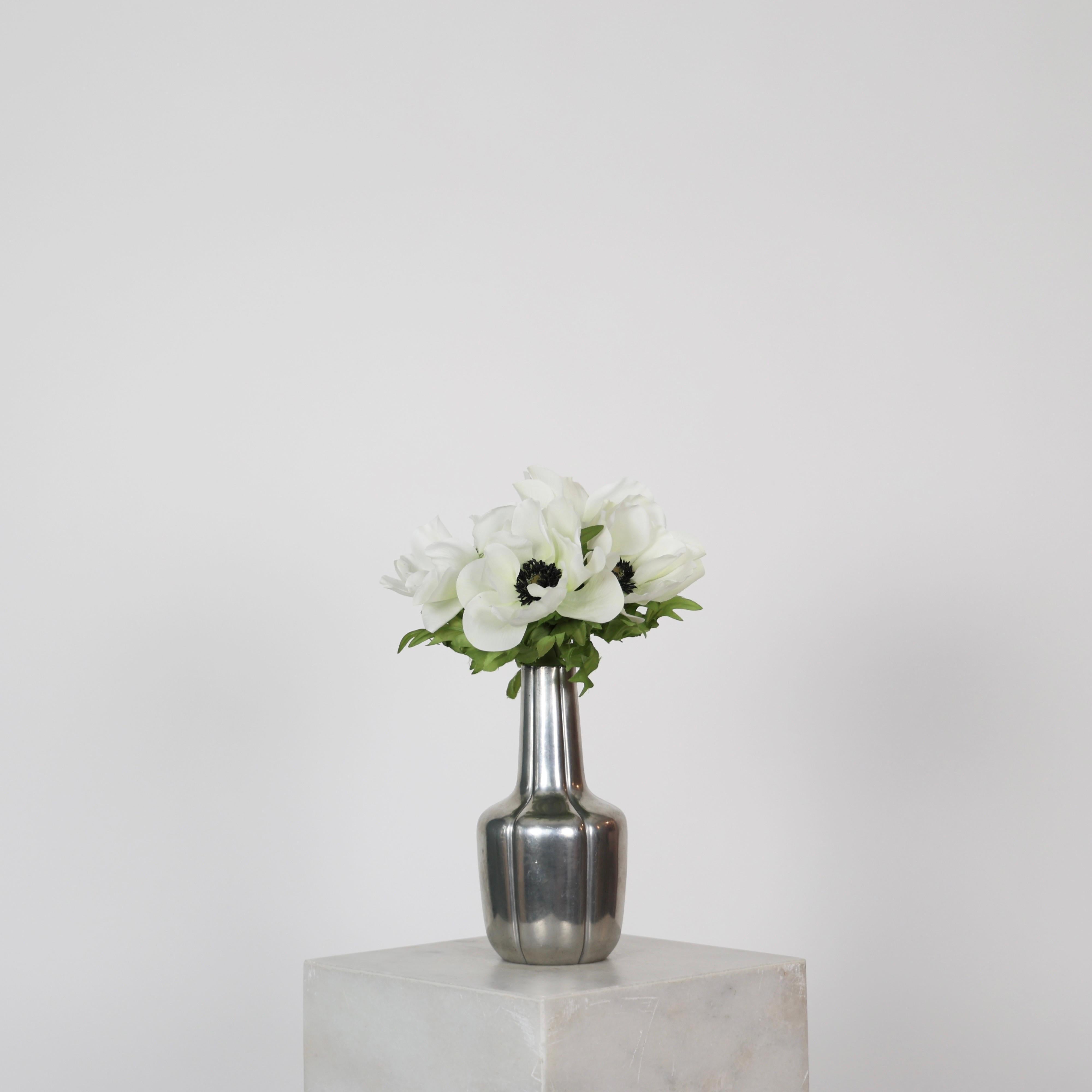 Vaso di peltro a forma di bottiglia realizzato da Just Andersen negli anni Cinquanta. 

* Vaso in peltro a forma di bottiglia con linee verticali
* Produttore: Just Andersen
* Stile: 2726
* Anno: 1952
* Condit: Buone condizioni. Incisione del