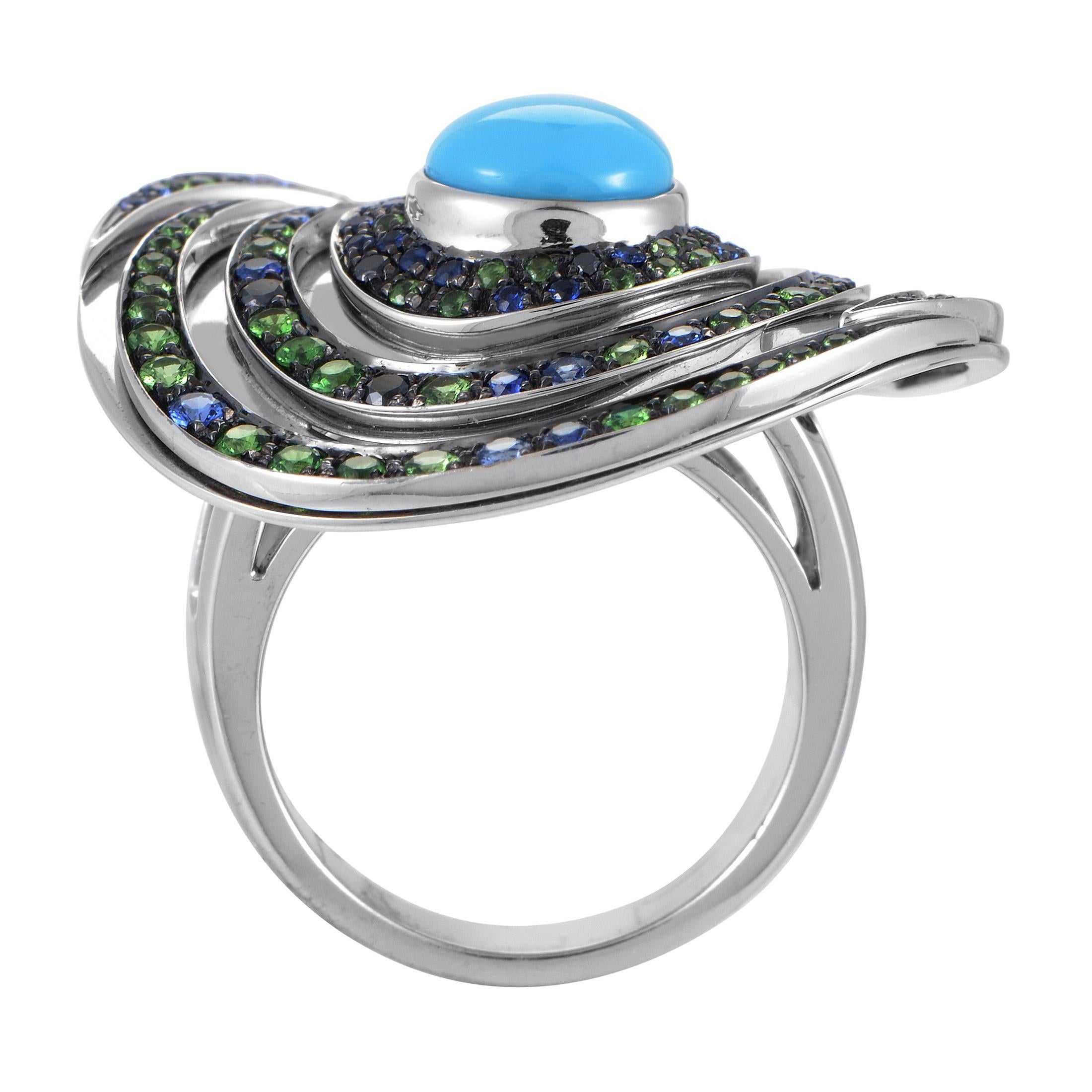 Designed in a spiraling and wonderfully crooked manner with a splendid turquoise stone set amidst a majestic arrangement of marvelous tsavorites and nifty sapphires, this astonishing 18K white gold ring from Boucheron is a fantastic sight to