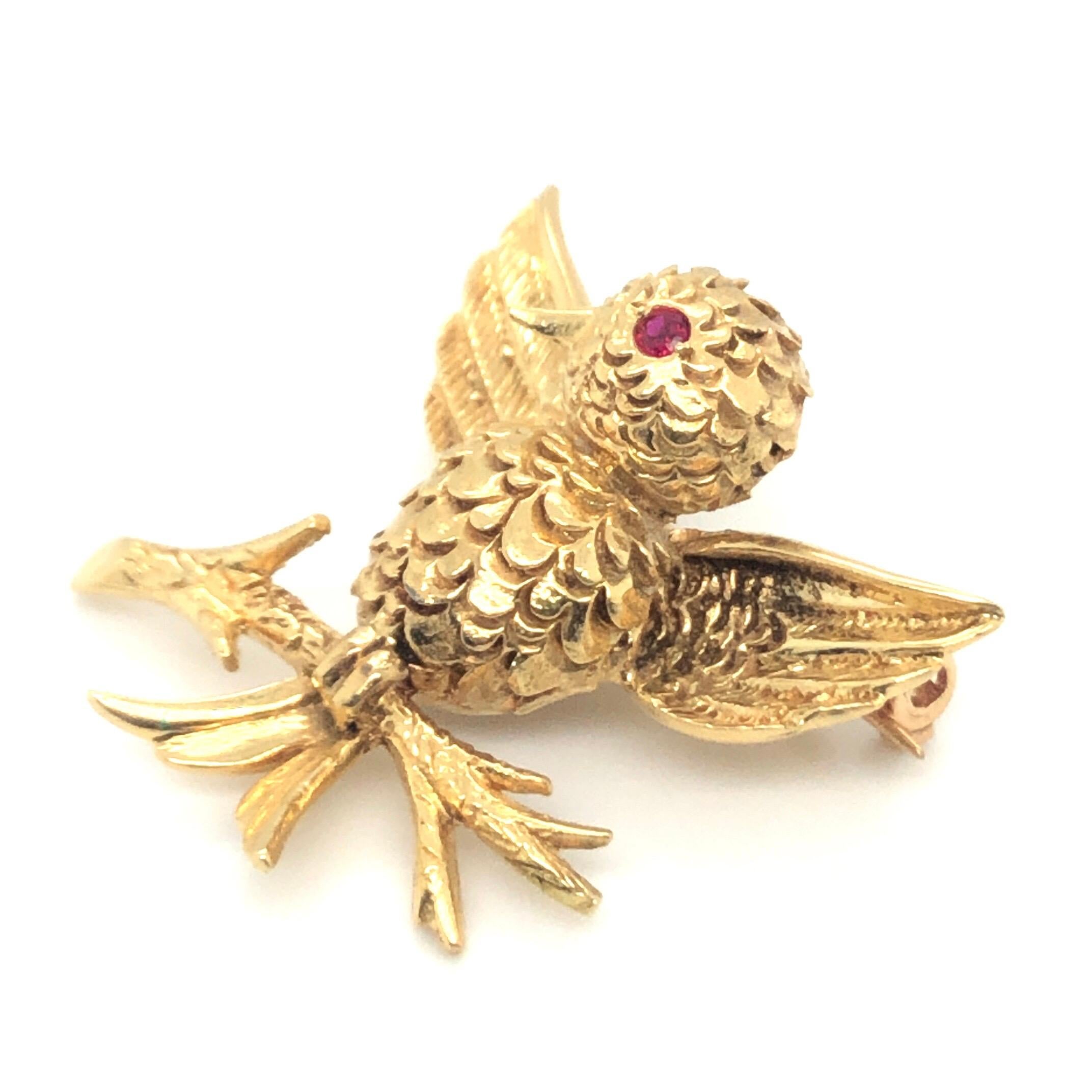 Adorable 18 karat yellow gold and ruby bird brooch pin by renowned French jewelry house Boucheron, 1960s.
Entirely crafted in 18 karat yellow gold and designed as a bird resting on a branch with open wings. The bird's eye is set with a tiny