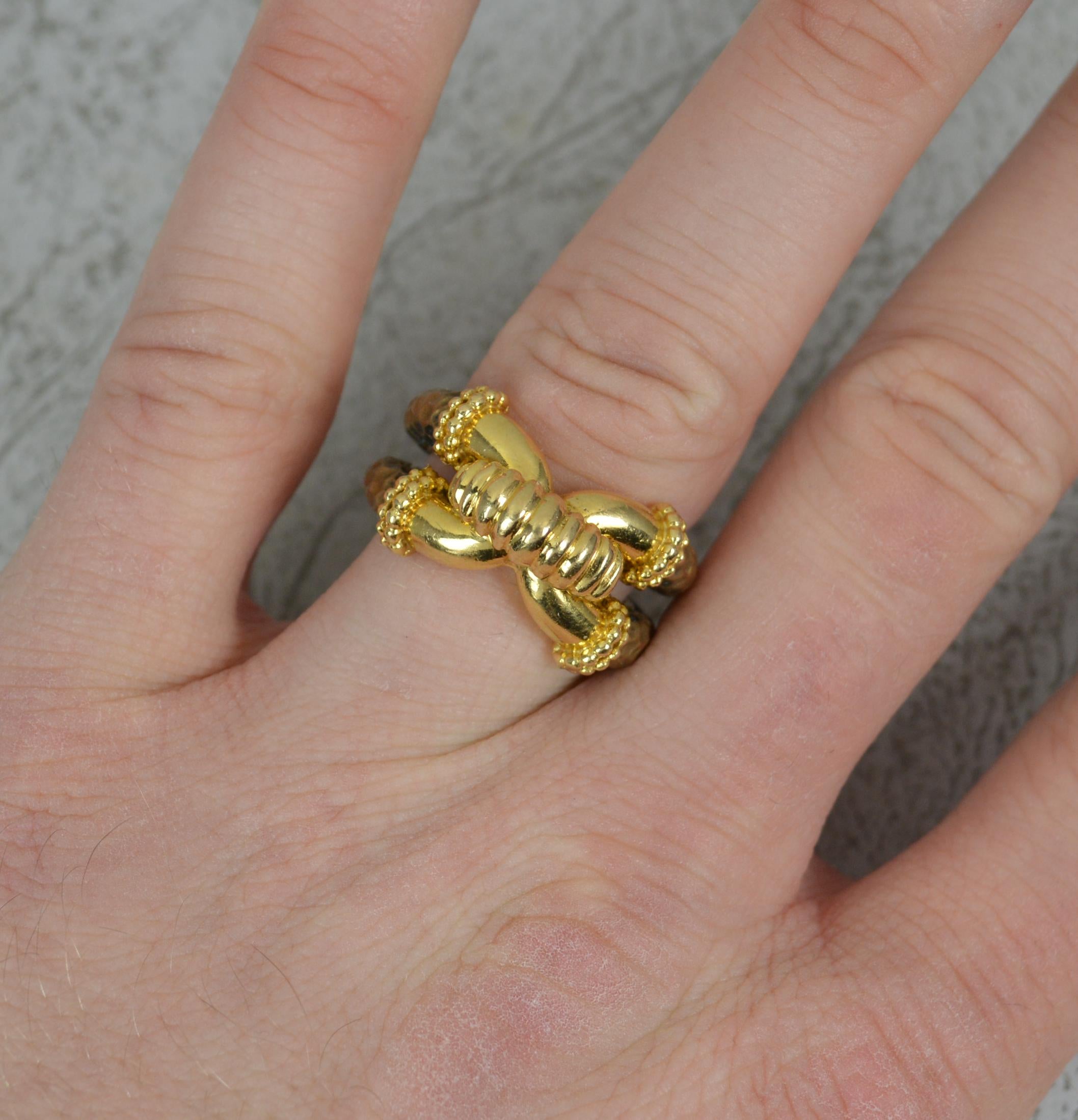 A stunning Boucheron ring.
Solid 18 carat yellow gold and bronze / airain example.
Designed as a knot or puzzle to front, 13mm wide.
The front in 18ct yellow gold, the split shoulders from airain, an alloy based on bronze creating a powerful