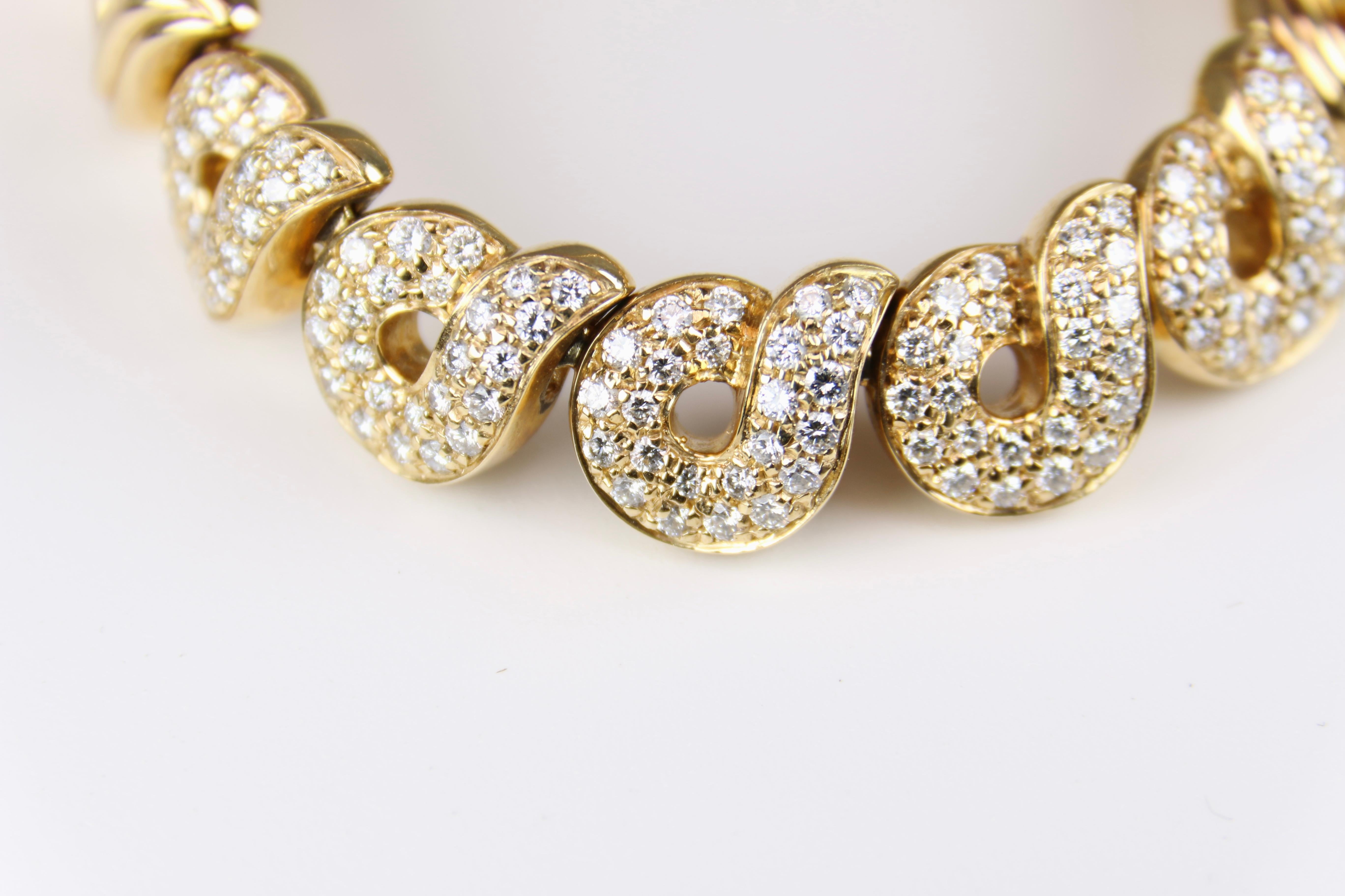 Designer necklace by Boucheron is a heavy 118.7 grams of 18K Yellow Gold and features ribbed swirl design links continuously wrapping the neck in an elegant pattern. Necklace features a hidden box clasp design secured with a fold under latch for