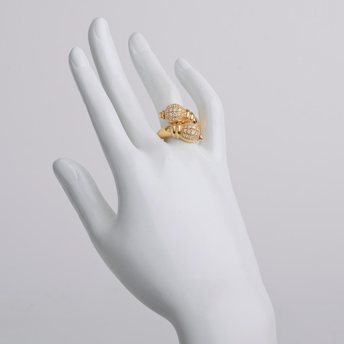 This classically styled 18k yellow gold ring wraps around the finger and ends with two, side-by-side incised globe-shaped finials set with pavé diamonds.
 
Numbered 'B-2687767' and signed 'Boucheron'
Size 8
