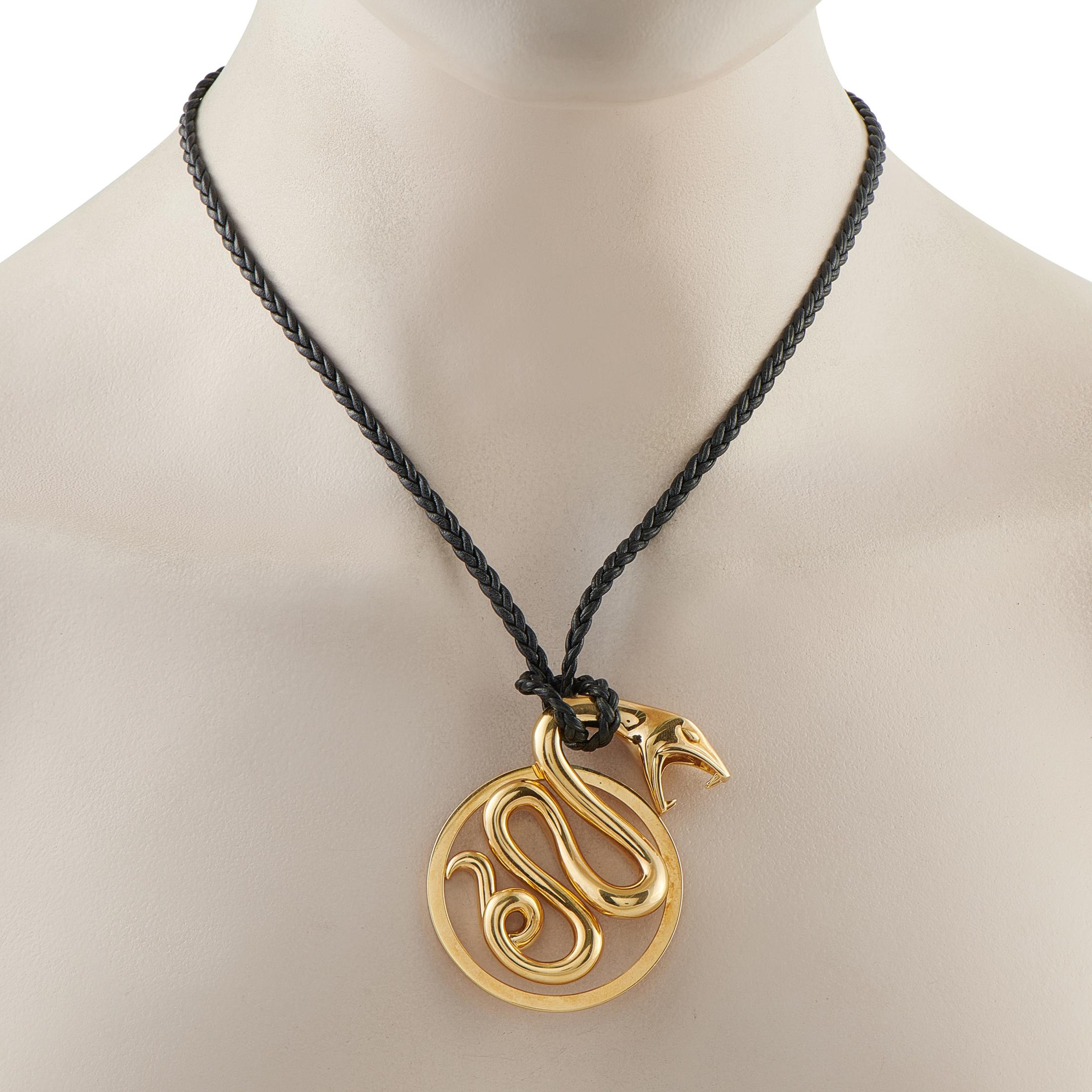 This Boucheron Serpent necklace is bold, confident, and will make a statement every time its worn. It features an 18K Yellow Gold circular snake pendant suspended from a 30 black cord. The pendant measures 2.38 long by 1.75 wide.This jewelry piece