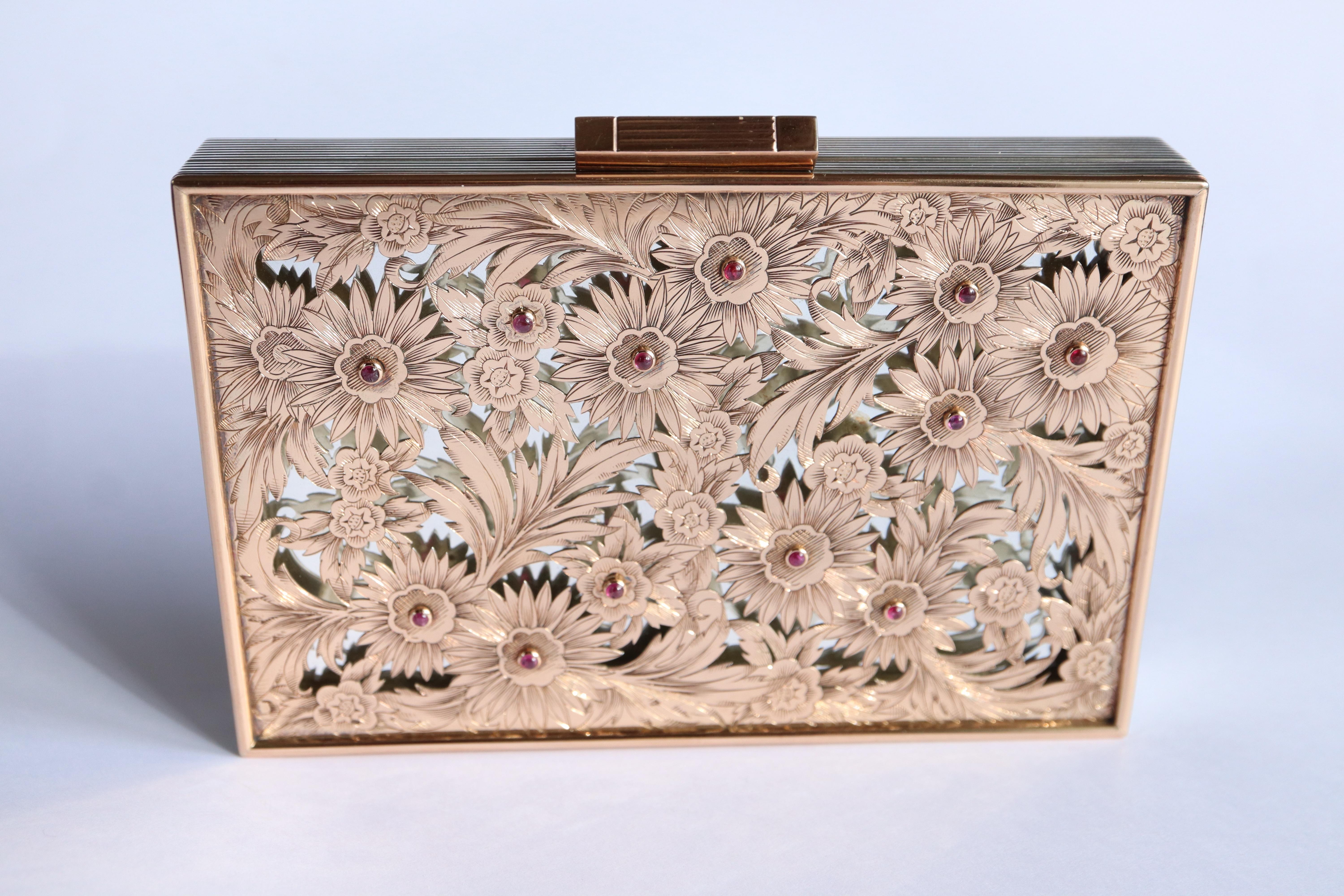 BOUCHERON, años 1940-1950 Estuche de belleza rectangular de plata estriada de 800 milésimas, la tapa decorada con una placa calada de oro rosa de 750 milésimas decorada con flores y follaje cincelados, doce pistilos están engastados con rubíes