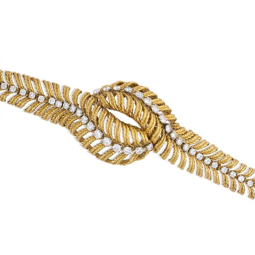 A textured and articulated gold and diamond bracelet of stylized bypass plume design, in 18K and platinum.  Boucheron, Paris; #755D. Atw 5.00 ct. diamonds.