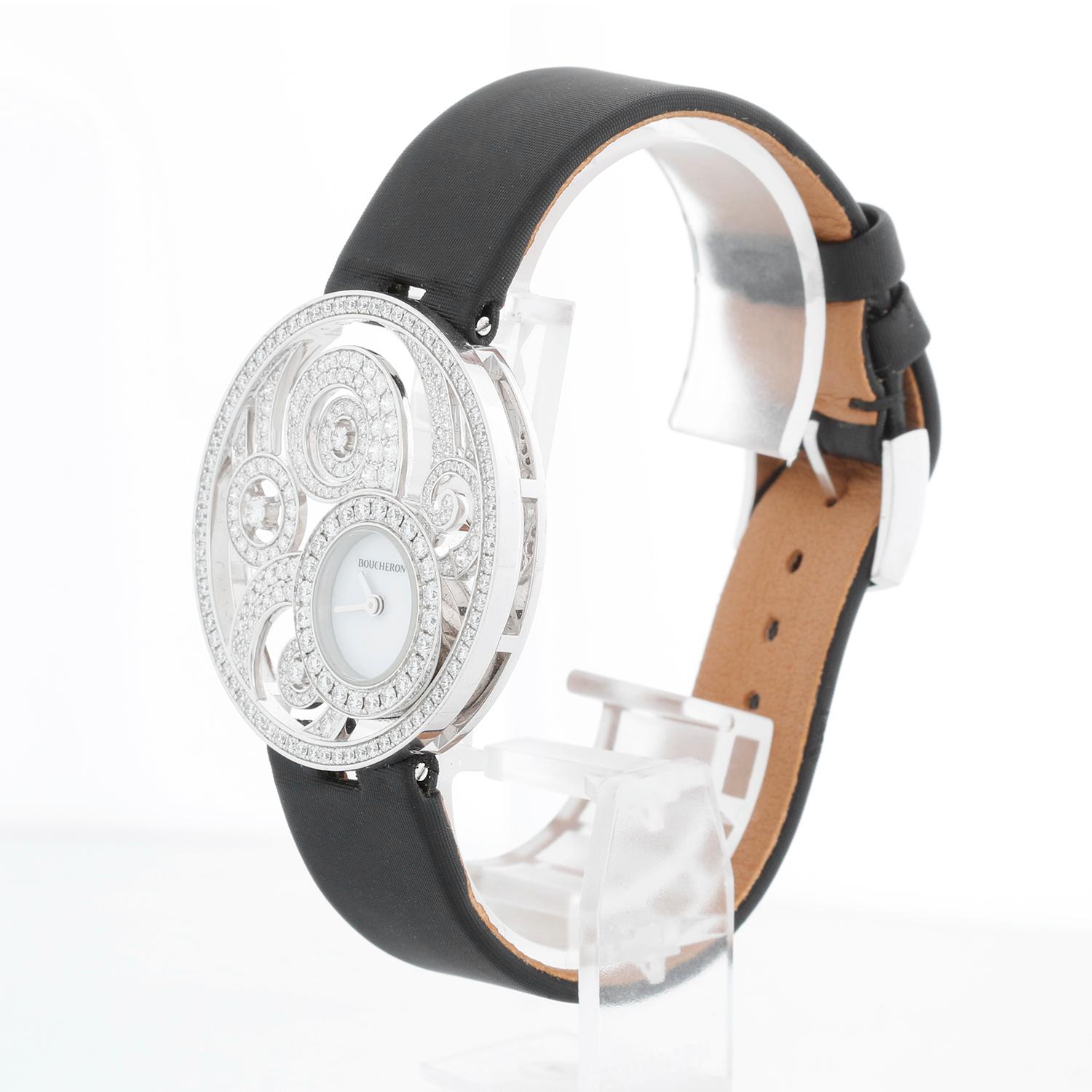 Boucheron Ajouree Volutee Ladies Diamond 18K White Gold Watch WA017301 - Quartz. 18K White gold surrounded by beautifully ornate open work sculpted Ava motifs set ( 38 mm). White mother of pearl dial. Black satin Boucheron strap with 18K Boucheron