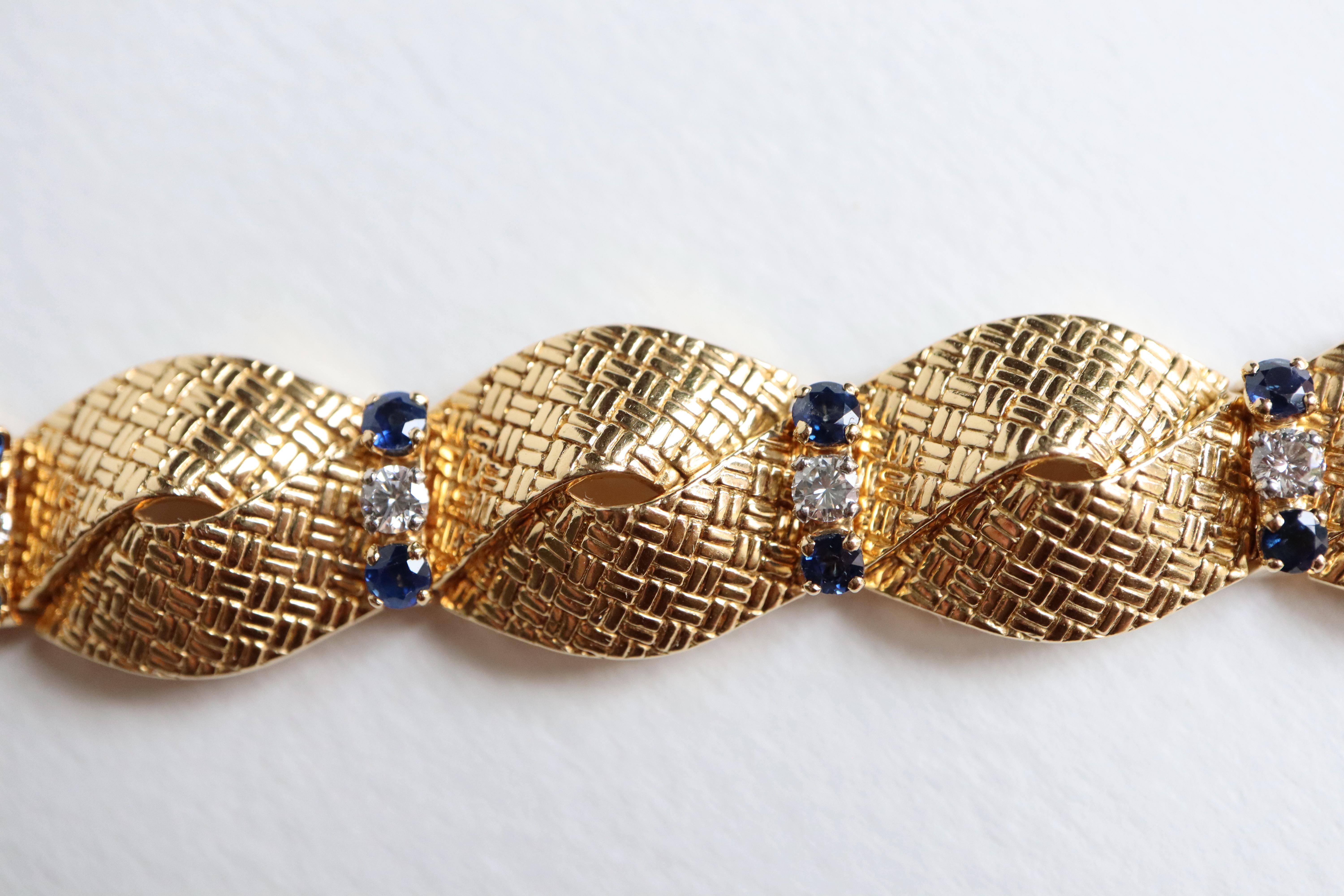 BOUCHERON Bracelet en or jaune 18 carats, saphirs et diamants. Deux rubans entrelacés retenus par 8 lingots d'or sertis chacun de deux saphirs et d'un diamant.
Or jaune 18 carats : Poinçon tête d'aigle
Signé : Boucheron
Poids brut : 46,2 g 