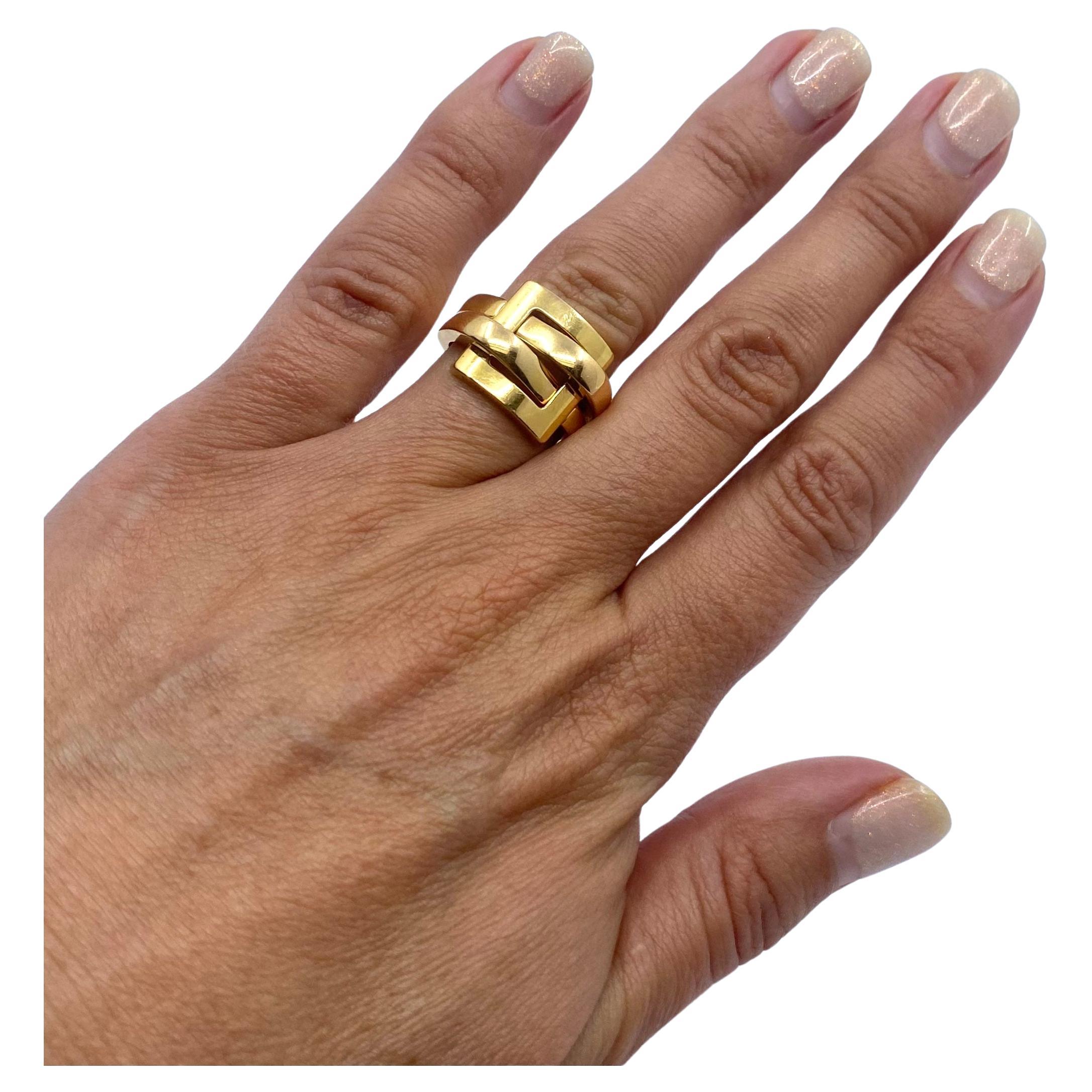 A Boucheron ring of buckle design, made in 18k gold.  The design consists of two polished gold loops that go through the square buckle and create the shank. This combo of the straight buckle’s lines and round loops makes the ring look unique. Being