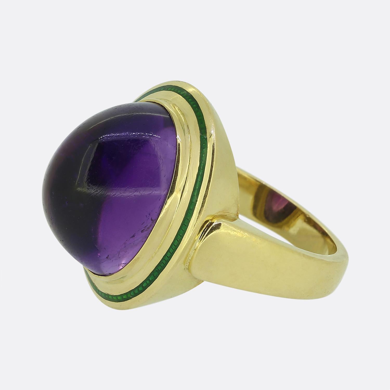 This is a striking cocktail ring from the renowned French jewellery designer, Boucheron. This vintage piece has been crafted from 18ct yellow gold and features a captivating cabochon-cut amethyst at the centre of the face showcasing a rich purple