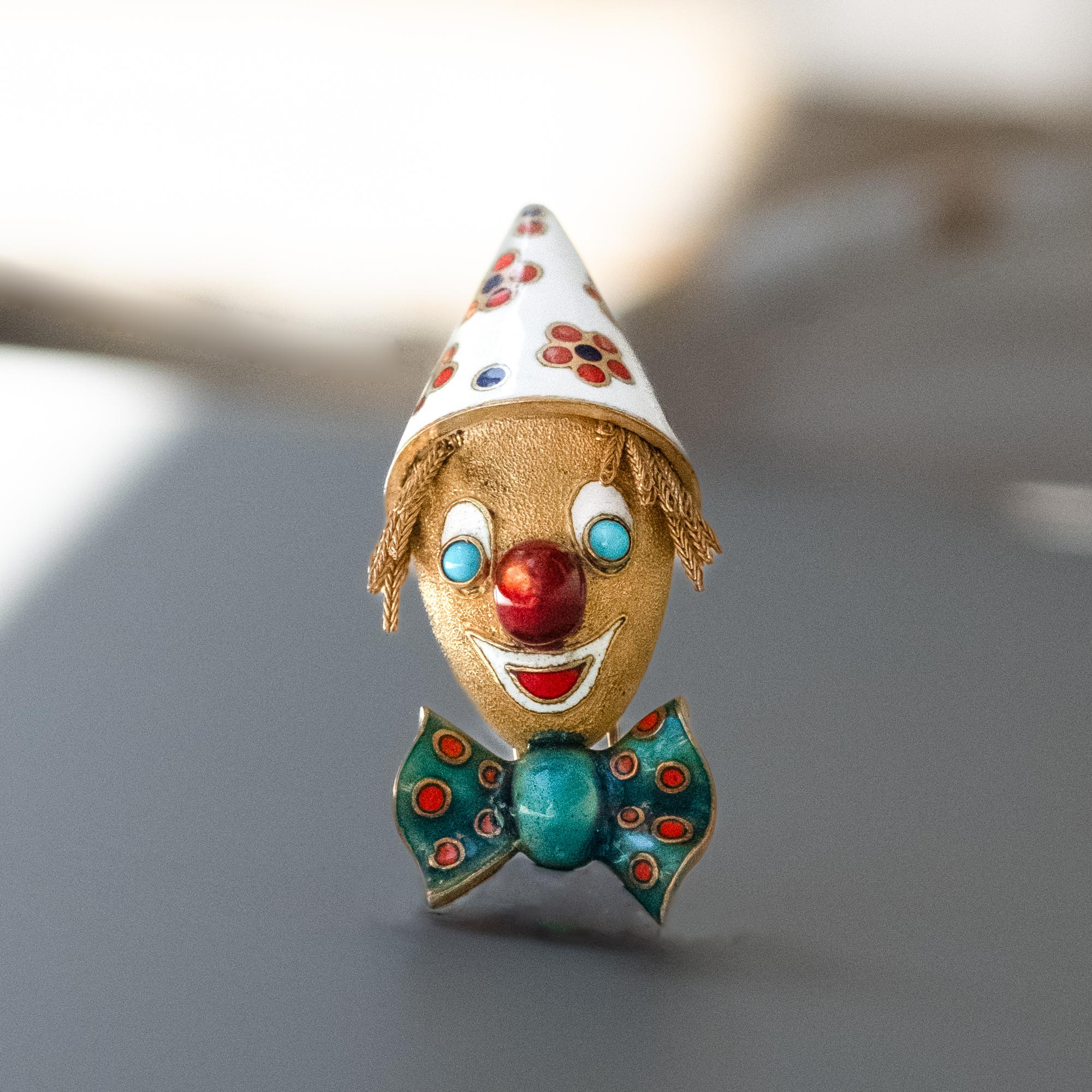 A Boucheron 'Clown Head' Brooch, in 18ct yellow gold, with turquoise beads eyes and enamel. 

Bearing the minimum 18ct warranty French stamp for export and London 1967 import stamps. 

Signed Boucheron.