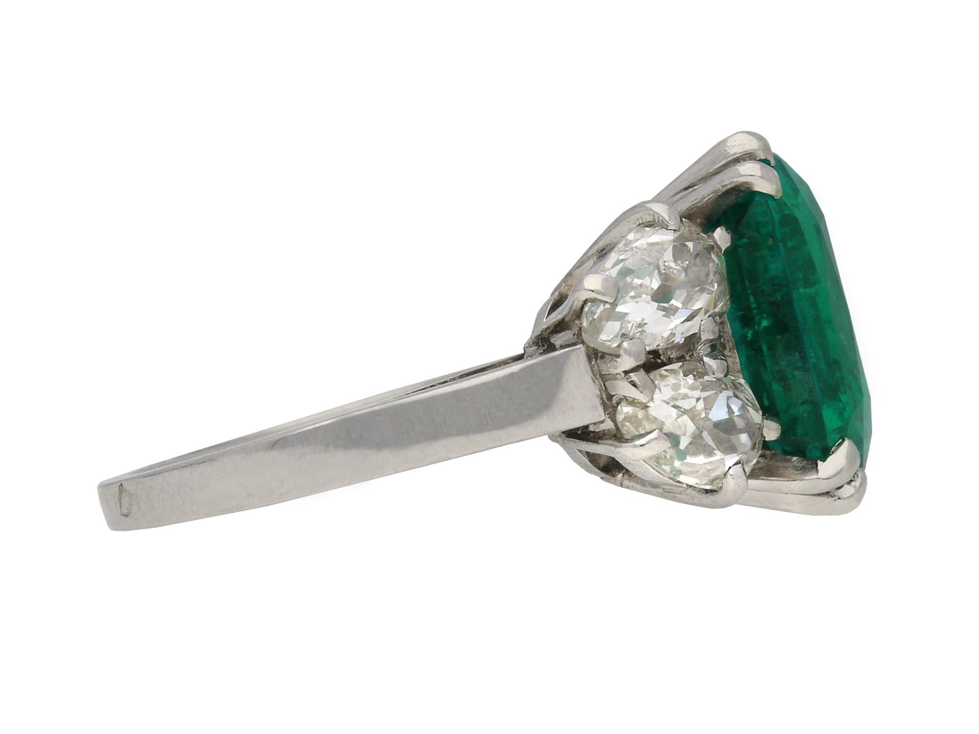 Boucheron Colombian emerald and diamond ring. Centrally set with a cushion shape old mine cut natural Colombian emerald with indications of minor clarity enhancement in an open back claw setting with an approximate weight of 6.20 carats, further