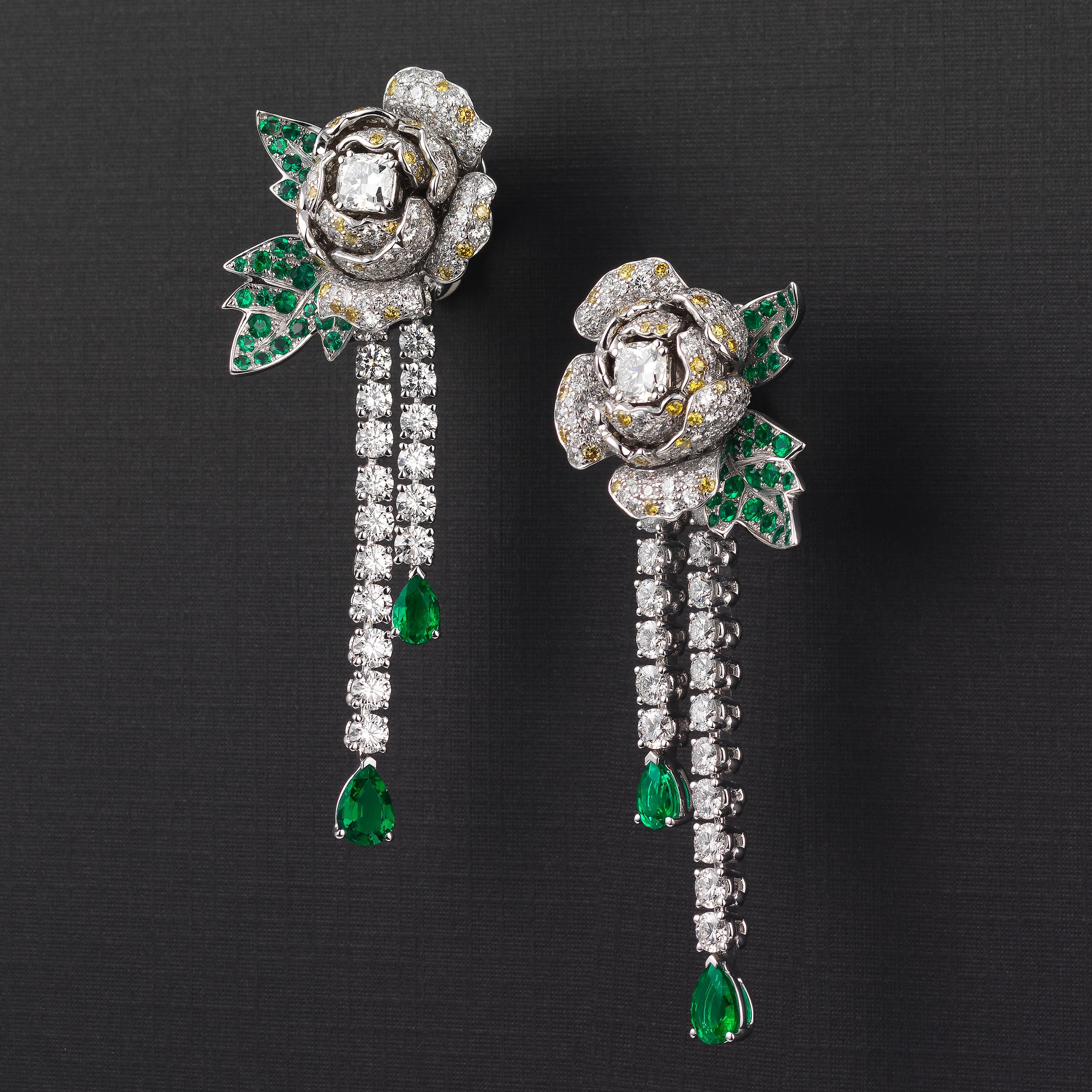 Ein exquisites Paar Boucheron-Tropfenohrringe mit Rosenmotiv aus 18 Karat Weißgold und mit ca. 12 Karat feinen weißen und gelben Diamanten und 4 Karat lebhaften grünen Smaragden besetzt. Die Ohrringe strahlen die feminine Eleganz und den Glamour der