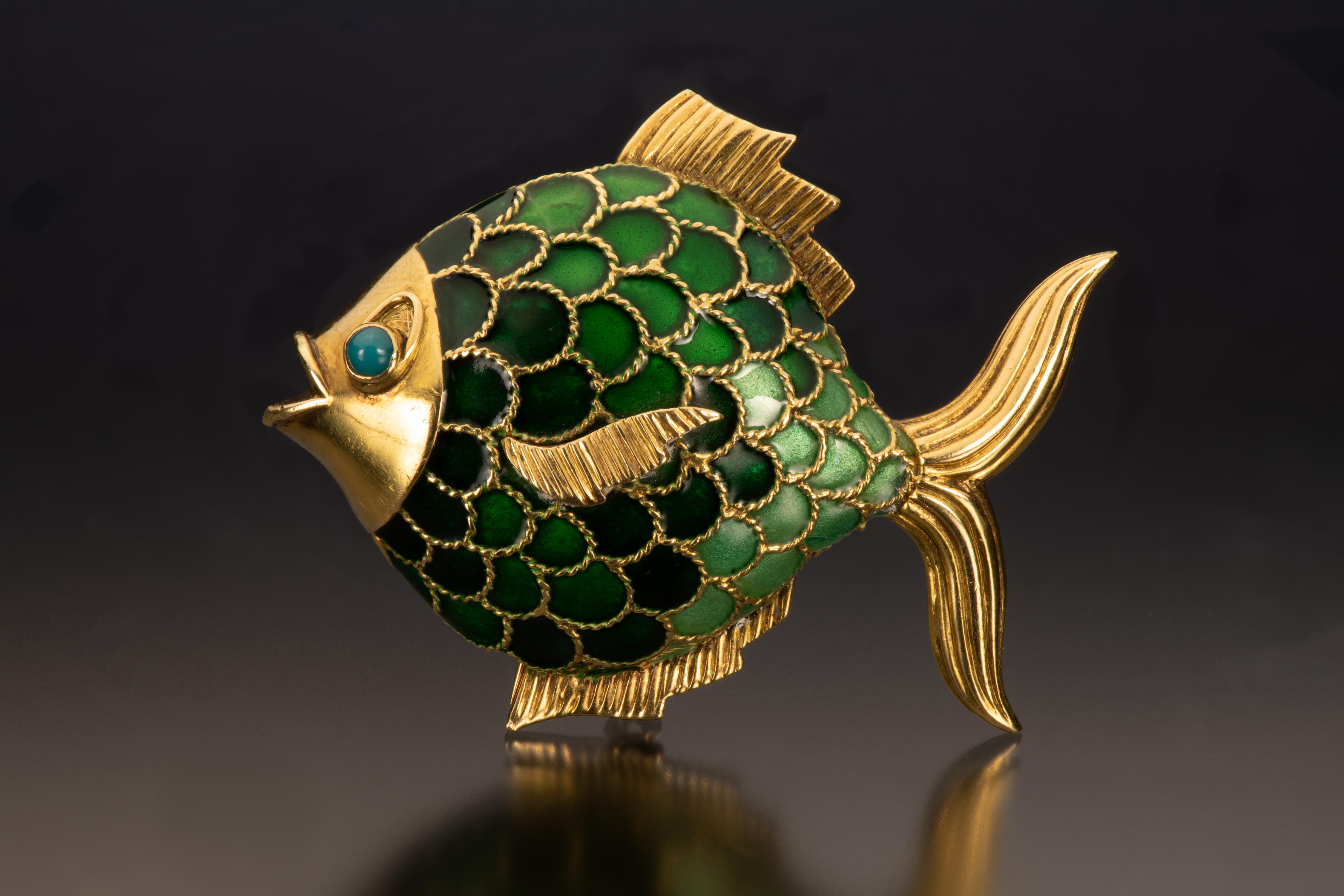 This vintage gold and enamel fish brooch illustrates the playful side of Boucheron. Shades of green enamel form the scales, and the 18k gold head is set with a cabochon gemstone eye.   

- Length is 1.75 inches and width is 2.25 inches