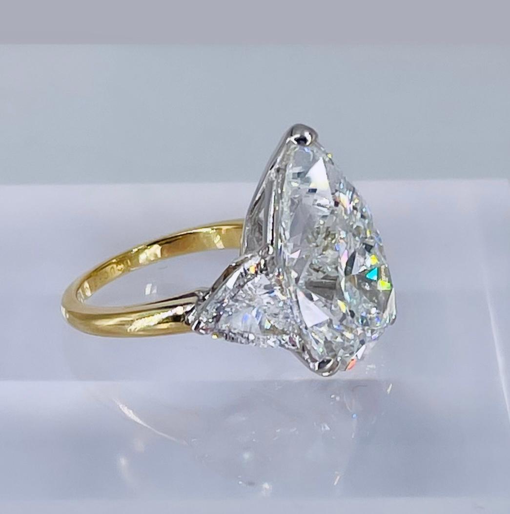This important, Boucheron, three-stone ring crafted in 18K yellow gold features a certified 11.22 carat pear shape diamond of G color and SI1 clarity as described by GIA grading report #6224413014. The center stone is flanked by a matched pair of