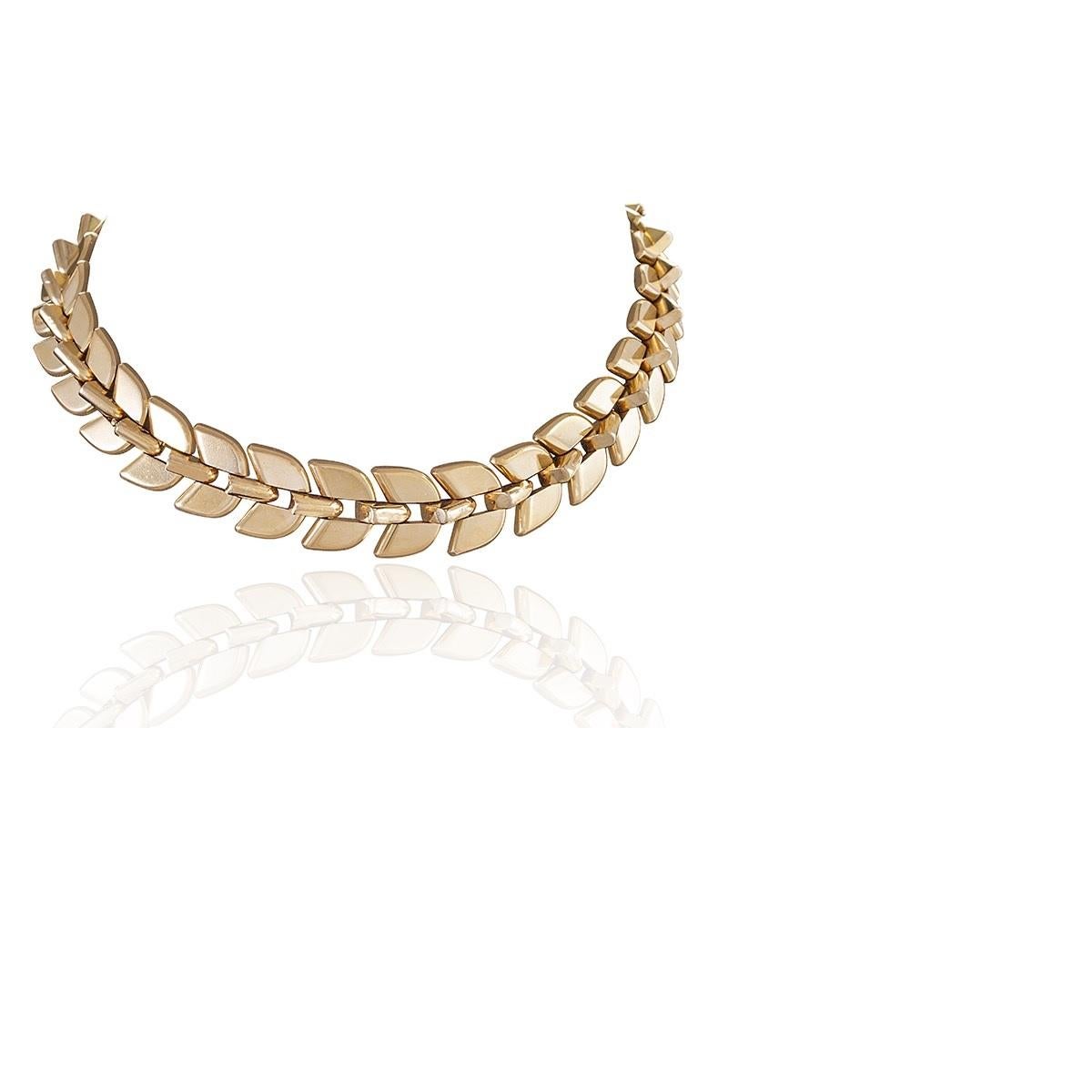 A French mid-20th century 18 karat gold necklace by Frederic Boucheron. The necklace, which elegantly and seamlessly breaks apart into two wearable bracelets, is comprised of highly polished rounded triangular section links, with two mirroring