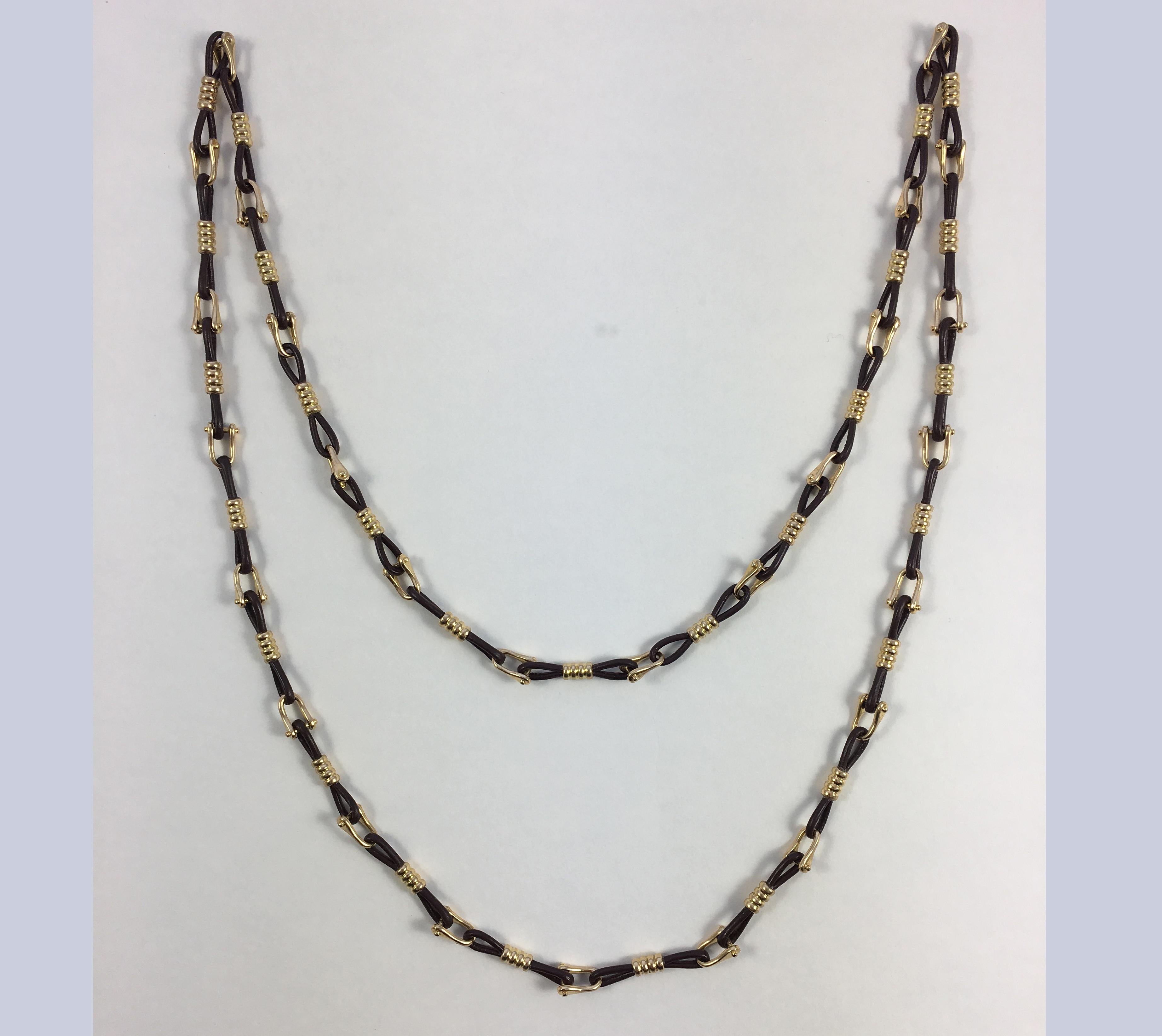 A very smart necklace by Boucheron Paris designed as gold stirrups separated by dark brown leather cords. Adapted from an original 'Nautilus Theme' necklace, the worn out jute sections have been replaced by leather to give this necklace a modern and