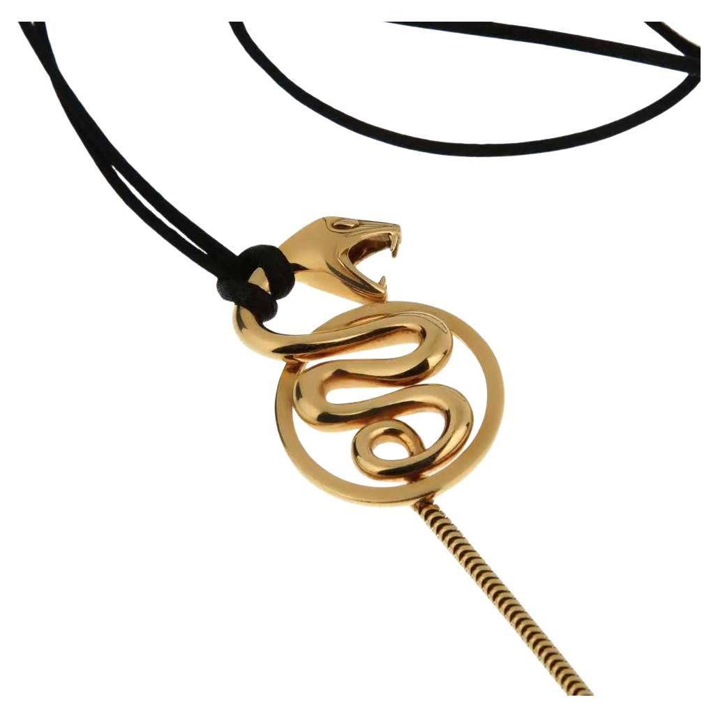 Boucheron 18 karat yellow gold snake pendant necklace, from the Kaa collection. The coiled serpent sits atop a circular frame with its tail slithering down. The tail is an 18 karat yellow gold snake chain extending an additional 2.75 inches from the