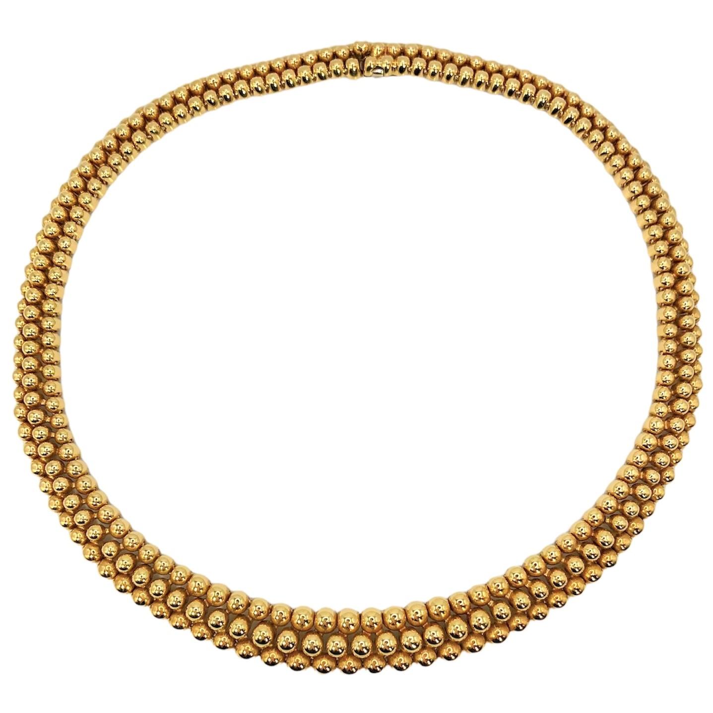 This lovely and tailored choker necklace by Boucheron was crafted and released late in the 20th century and is wonderful in it's simplicity. It is designed as three rows of graduating polished gold beads terminating in a hidden clasp. Measures 14