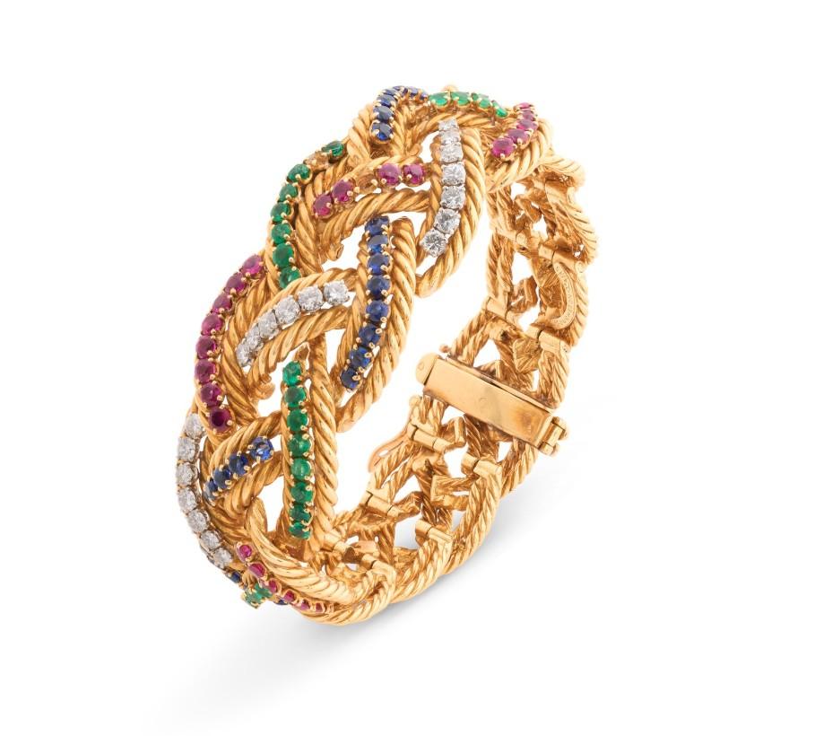 Boucheron - Bracelet en or tressé, multigemmes et diamants

Description :
Réalisé en or jaune 18 carats, ce bracelet Boucheron vintage présente un motif de corde tressée distinctif, entrelacé de bandes vibrantes de diamants, saphirs, émeraudes et