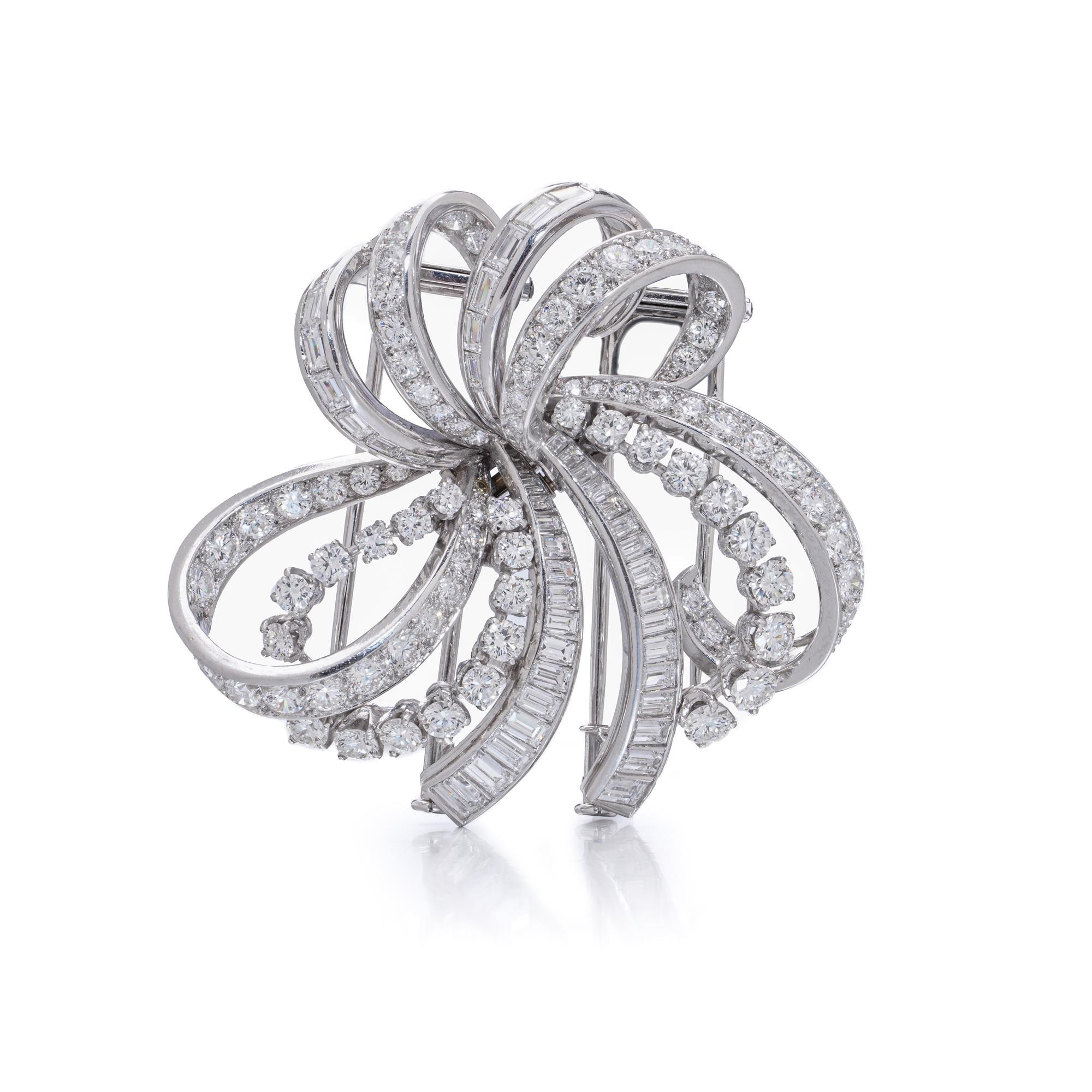 Una sorprendente e versatile spilla Boucheron a doppia clip realizzata in oro bianco 18 carati, disegnata come un fiocco stilizzato a spirale con forme di nastro asimmetriche. La composizione dinamica è incastonata in pavé di diamanti rotondi con