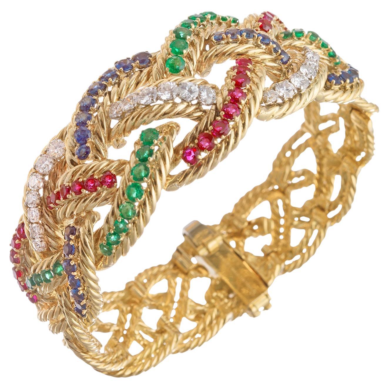 Bracelet vintage Boucheron Nature d'un design/One ajouré en or jaune 18k, le devant accentué par des rubis naturels de taille ronde, des émeraudes, des saphirs et des diamants. Le design tressé mesure environ 26,37 mm à l'avant et se rétrécit à