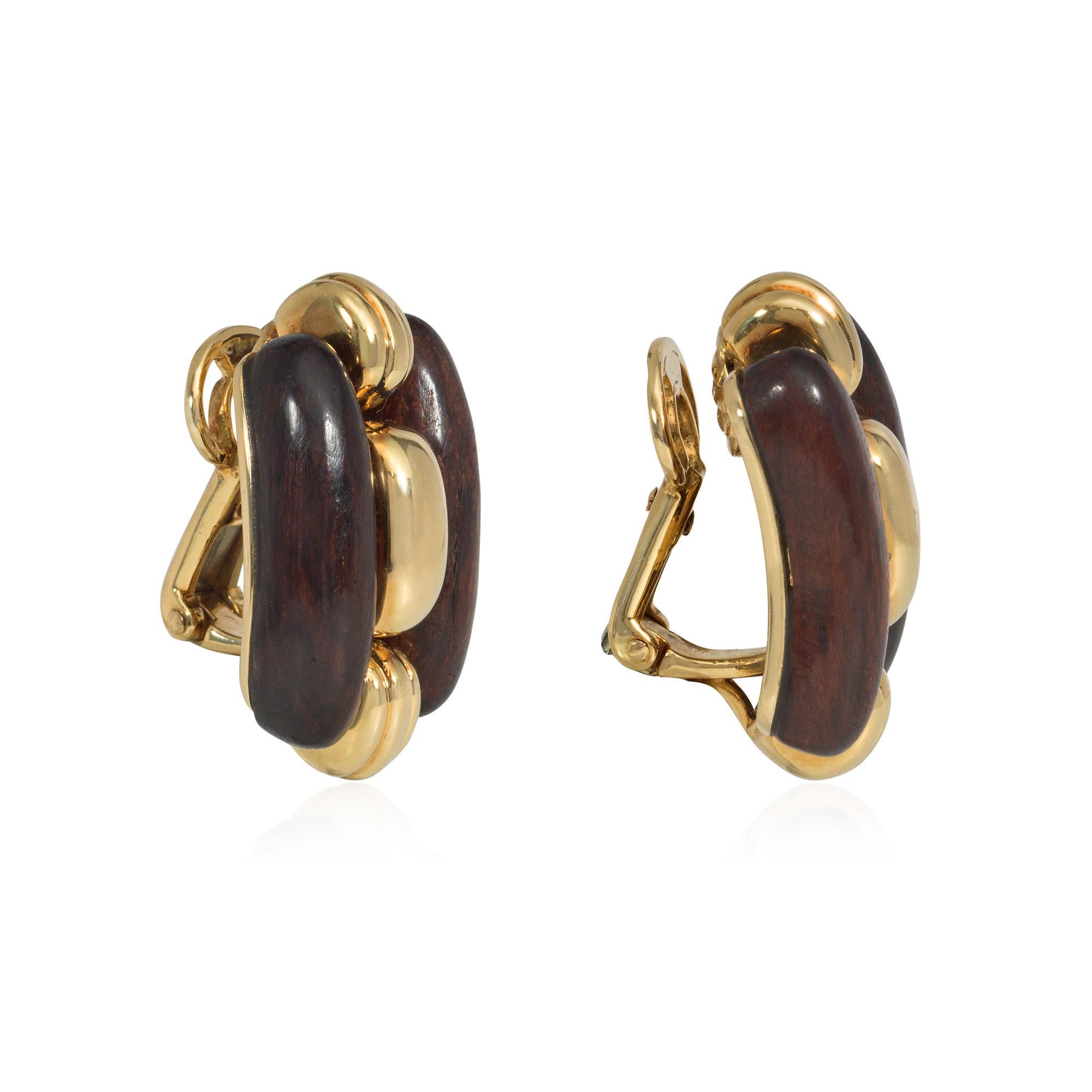 A pair of gold and wood clip earrings comprised of smooth and ridged gold segments, flanked by polished wooden borders, in 18k. Boucheron, Paris #PC870281