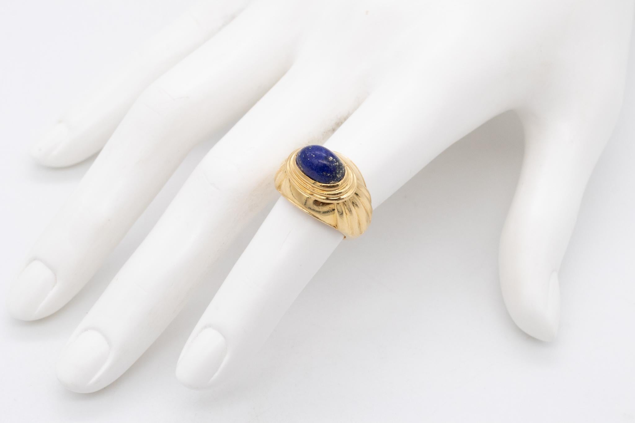 Jaipur cocktail ring designed by Boucheron.

A classic and iconic ring crafted in Paris France in solid yellow gold of 18 karats, with deco fluted stepped patterns. 

Bezel set on top, with one oval cabochon cut (7 x 10 x 5 mm) of natural blue lapis