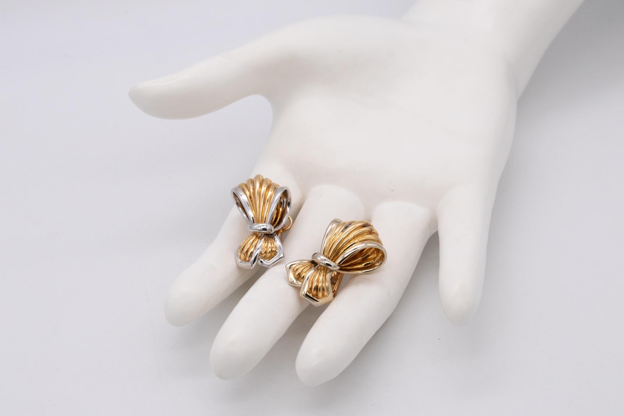 Paire de boucles d'oreilles en forme de rubans conçues par Boucheron.

Une boucle à clip moderne et surdimensionnée fabriquée à Paris, en France, par la maison Boucheron. Cette paire a été fabriquée en or jaune et blanc poli de 18 carats et est
