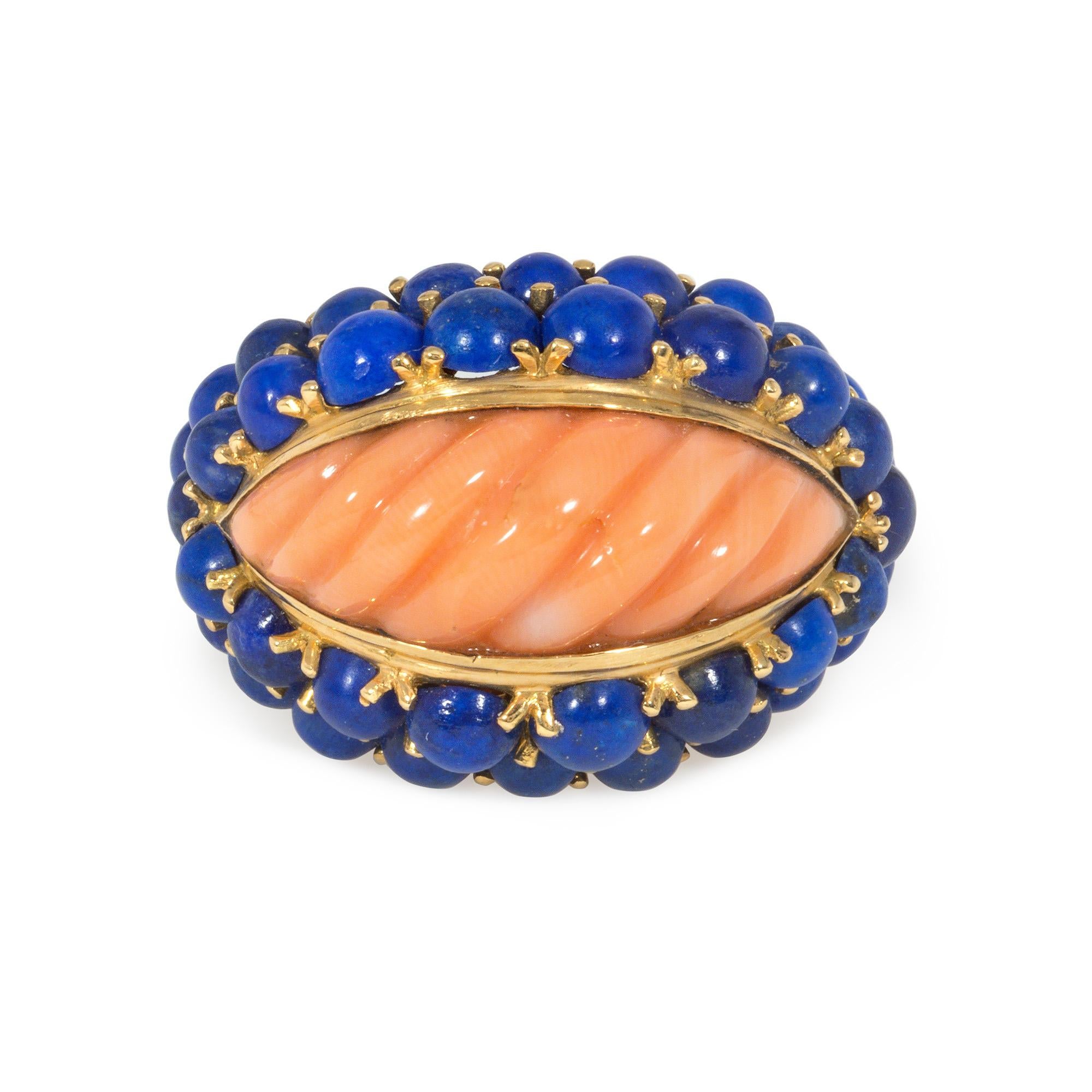 A mid-century gold, coral, and lapis bombé style ring centering on a navette-shaped, carved coral in a two-row cabochon lapis surround, in 18k. Boucheron, Paris. #49731.  Face-up: approximately 5/8