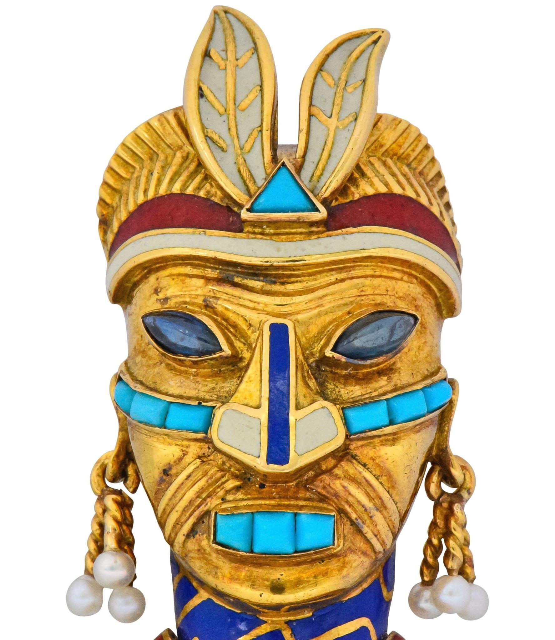 Featuring a tribal mask with channel set calibré turquoise and marquise cabochon sapphire eyes

Accented by red, white and blue enamel 

Accompanied by articulated earring tassels terminating in round, natural, freshwater seed pearls

Completed by