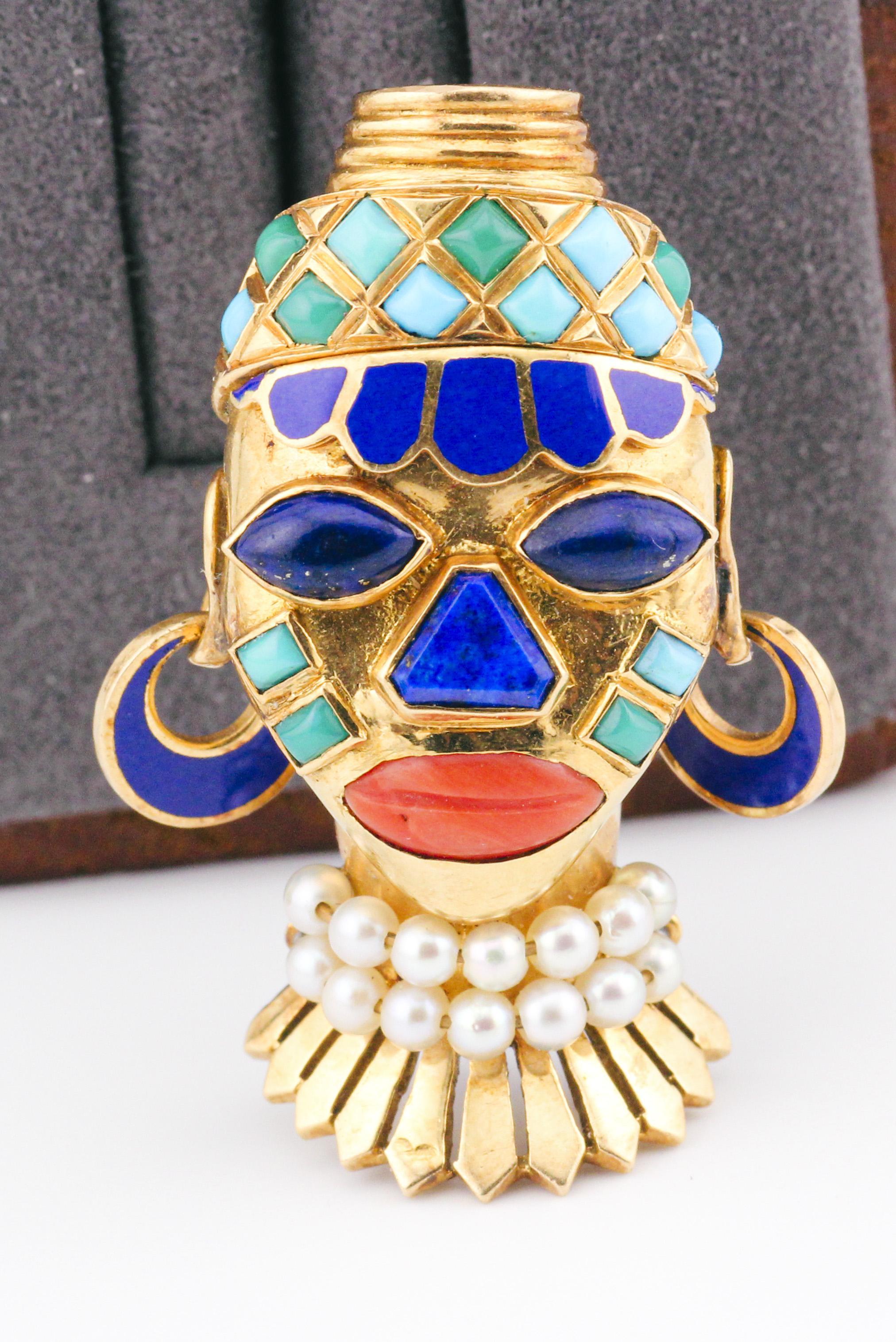 Step into a world of opulence and cultural allure with the Boucheron Retro Era African Mask Lapis Turquoise Pearl Enamel 18K Gold Brooch. This exquisite piece seamlessly marries the elegance of retro design with the rich cultural heritage of African