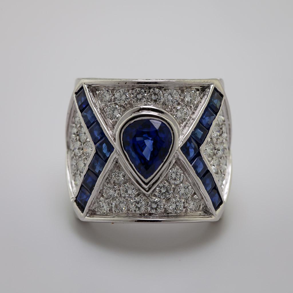 Featuring (1) bezel set pear-cut deep blue sapphire, 1.80 ct., accented by (14) channel set
calibre-cut matching blue sapphires, 1.25 cts. tw., enhanced throughout by (58) full-cut
diamonds, 2.50 cts. tw., all set in a beautifully hand-crafted wide