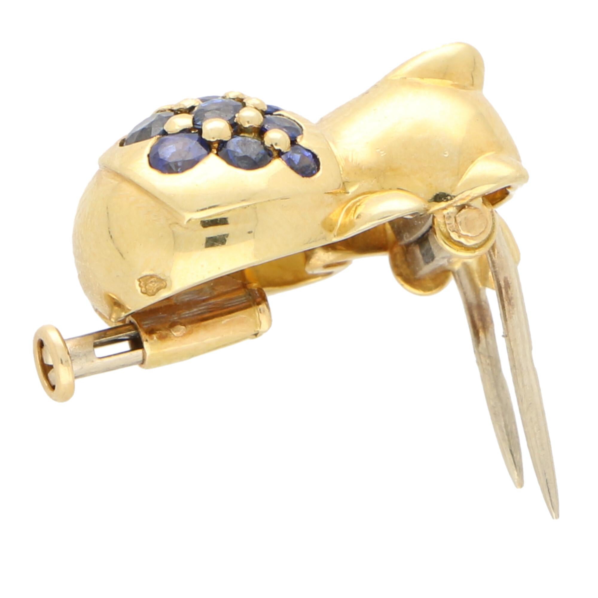 An incredibly sweet sapphire Boucheron Teddy bear pin/brooch set in 18k yellow gold.

This cute little piece depicts a lying down Teddy bear which is pave set on the back with 12 round cut clue sapphires. The bear is beautifully detailed and is