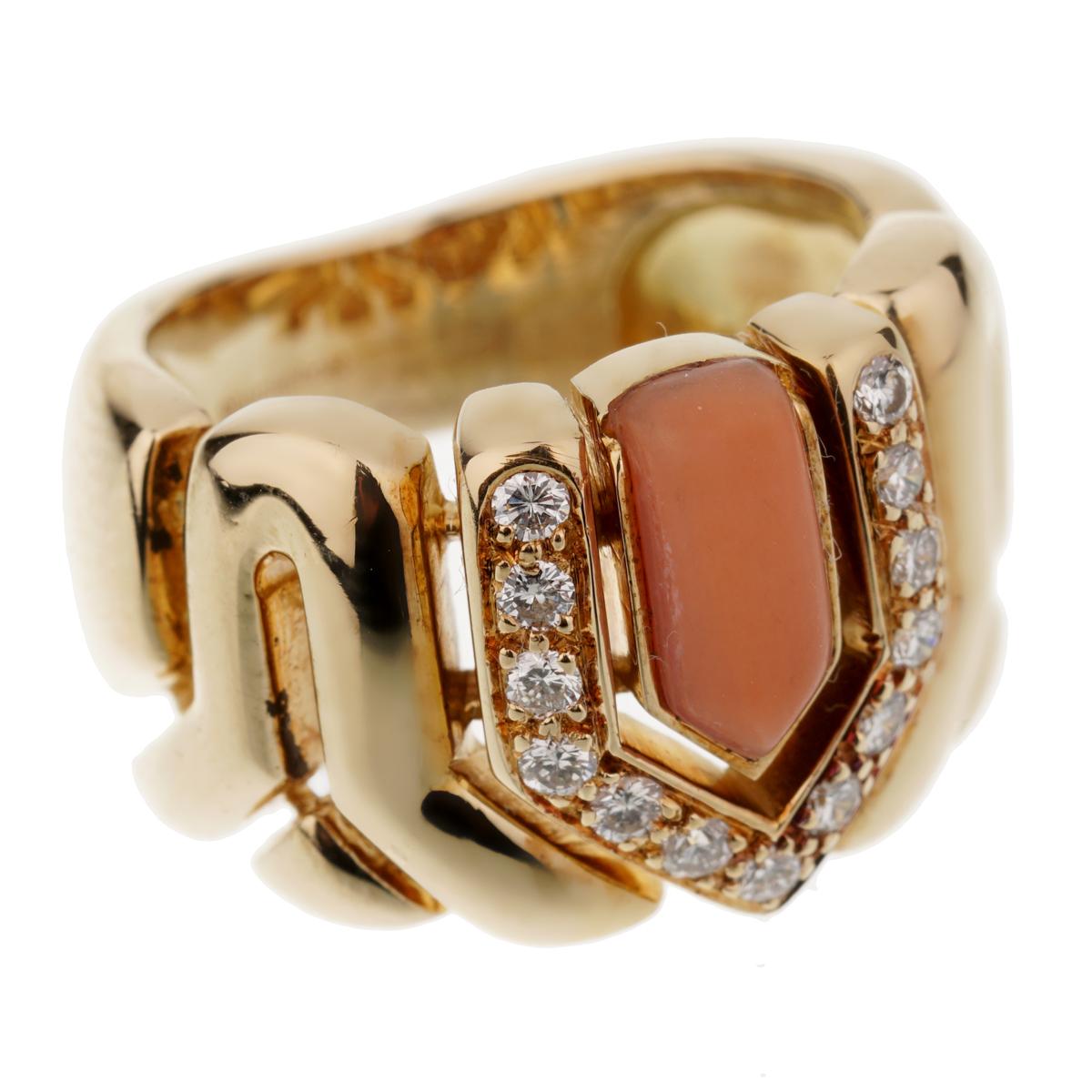 A fabulous vintage Boucheron ring showcasing a coral surrounded by 13 of the finest Boucheron round brilliant cut diamonds set in 18k yellow gold. The ring measures a size 4 1/2 and can be resized.