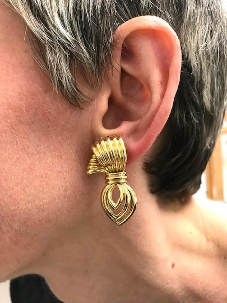 A beautiful pair of vintage Boucheron 18k gold earrings designed as a whimsical bow.
The earrings showcase an amazing workmanship. The upper part is made of ribbed textured gold. The dangling drop-shaped part is open-work. It's attached with a