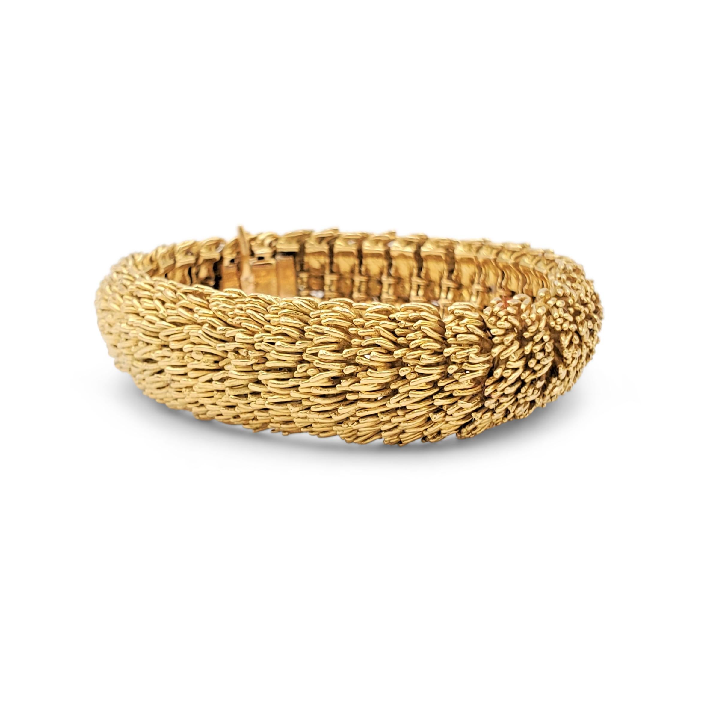 Authentic flexible Boucheron bracelet comprised of feather-like textured links crafted in 18 karat yellow gold. Signed Boucheron Paris, with serial number and hallmarks. The bracelet measures 7 inches in length. Not presented with the original box