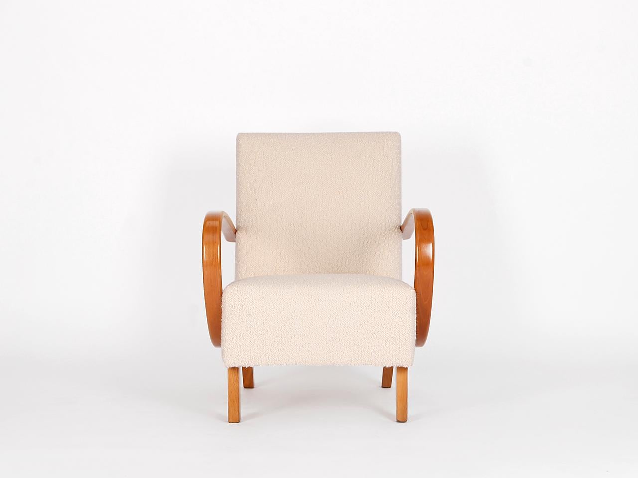 This armchair by Jindrich Halabala for Spojene UP Zavody was produced during the 1940s. The piece has been completely restored with a new spring core. With a wonderfully soft english cover boucle fabric made of wool. This completely restored chair