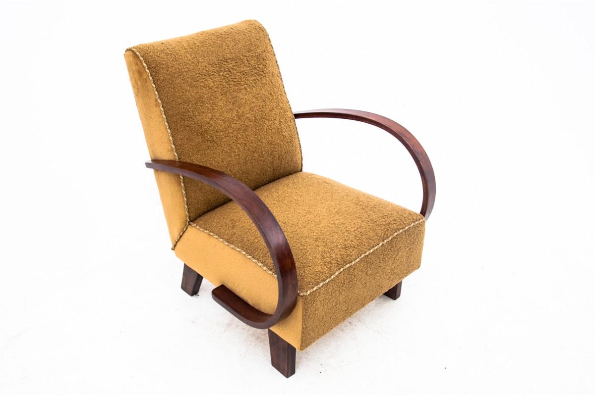 A cult armchair designed by J. Halabala in the art deco style, made around 1930. The seat and backrests are upholstered in a pleasant boucle fabric. The whole rests on straight legs, and bent wooden armrests add style. Very good condition, after