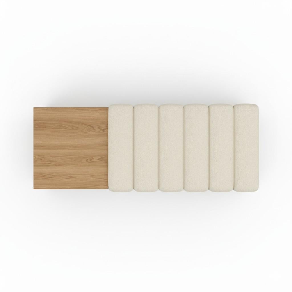 A contemporary rectangular bench combining natural materials and sculptural form. The design features two distinct sections: a solid oak block on one side functioning as a side surface, and a plush seating area upholstered in rich boucle'. The seat